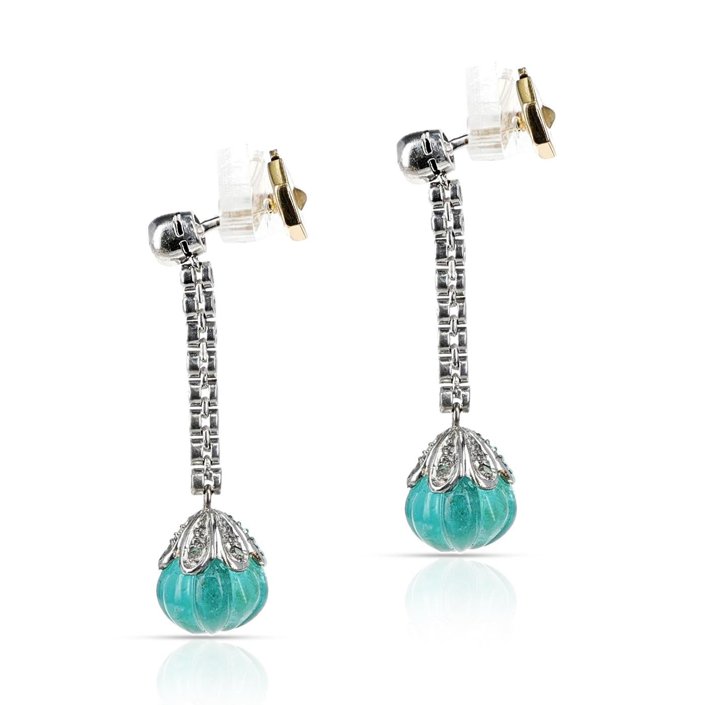 A pair of Round Diamond and Emerald Carving Dangling Earrings made in 18 Karat White Gold. The length is 1.20 inches. The total weight of the earrings is 6.86 grams. The total weight of the Emerald Carving is 8.65 carats. 