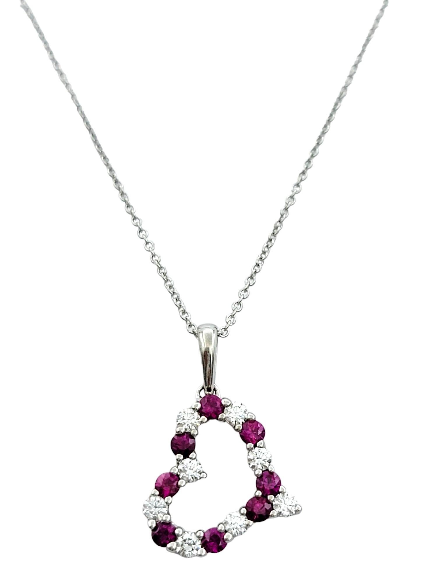 This enchanting necklace is a testament to love and sophistication. Crafted in 14 karat white gold, it features an open heart design adorned with alternating rubies and diamonds, creating a captivating contrast that radiates elegance and charm.

The