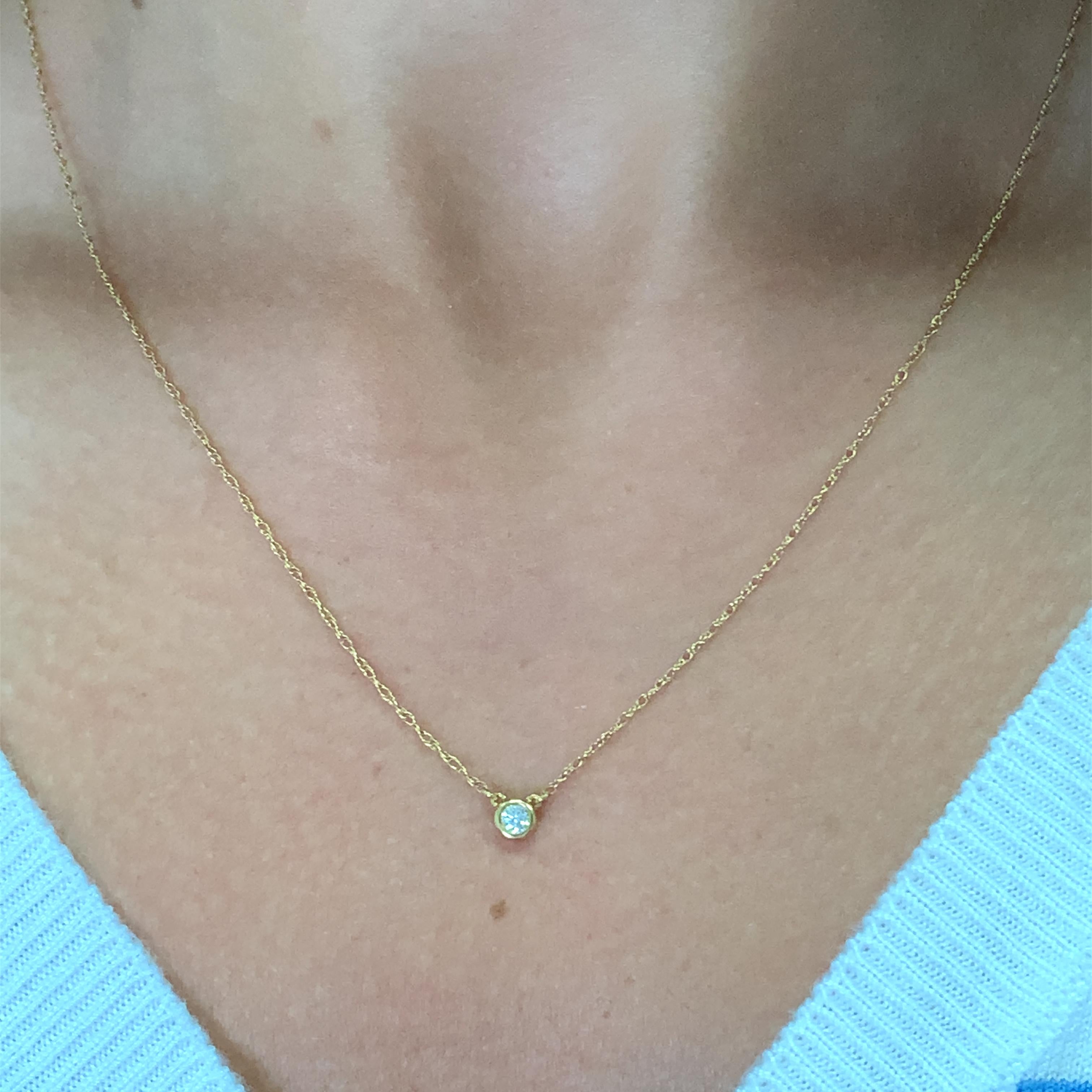 Add a touch of elegance to your outfit with this beautiful solitaire pendant necklace. The pendant is crafted with 18ct yellow gold and features a round diamond with a total carat weight of 0.10. The necklace is 18 inches long and has a chain type