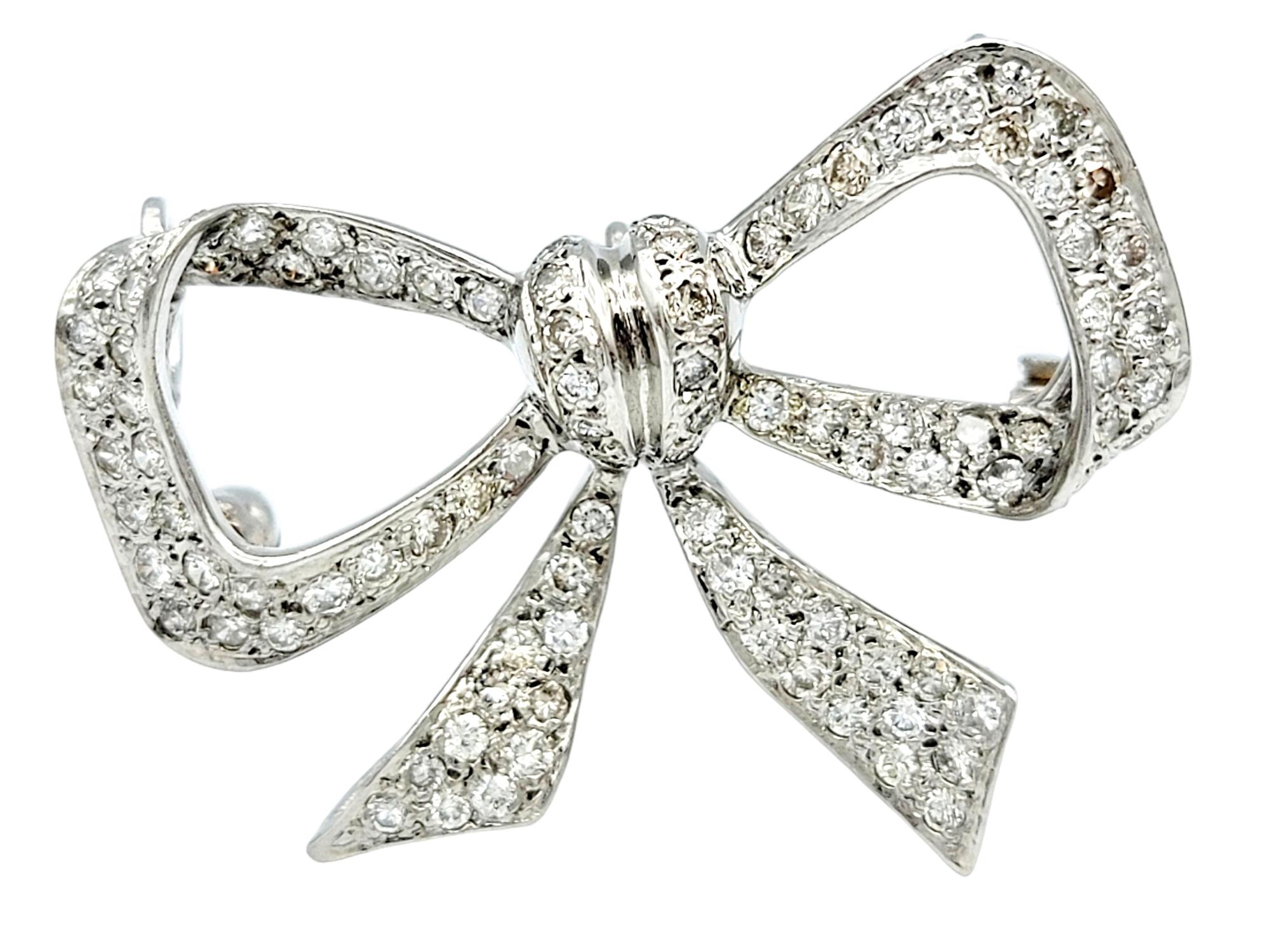 This versatile bow/ribbon design piece, set in 14 karat white gold, exudes a blend of elegance and luxury. Adorned with a stunning array of diamonds, it sparkles and shimmers like a radiant gift waiting to be unwrapped. The unique feature of this