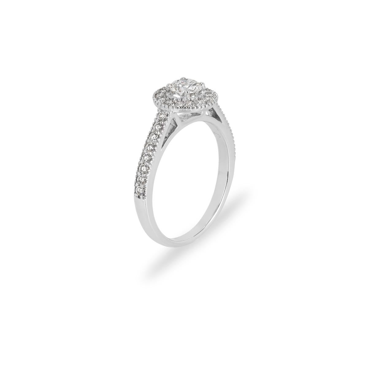 A sparkly 18k white gold diamond ring. The ring comprises of a round brilliant cut diamond in the centre weighing 0.41ct, H colour and VS in clarity. The centre diamond is accentuated by a halo of round brilliant cut diamonds, complemented by pave