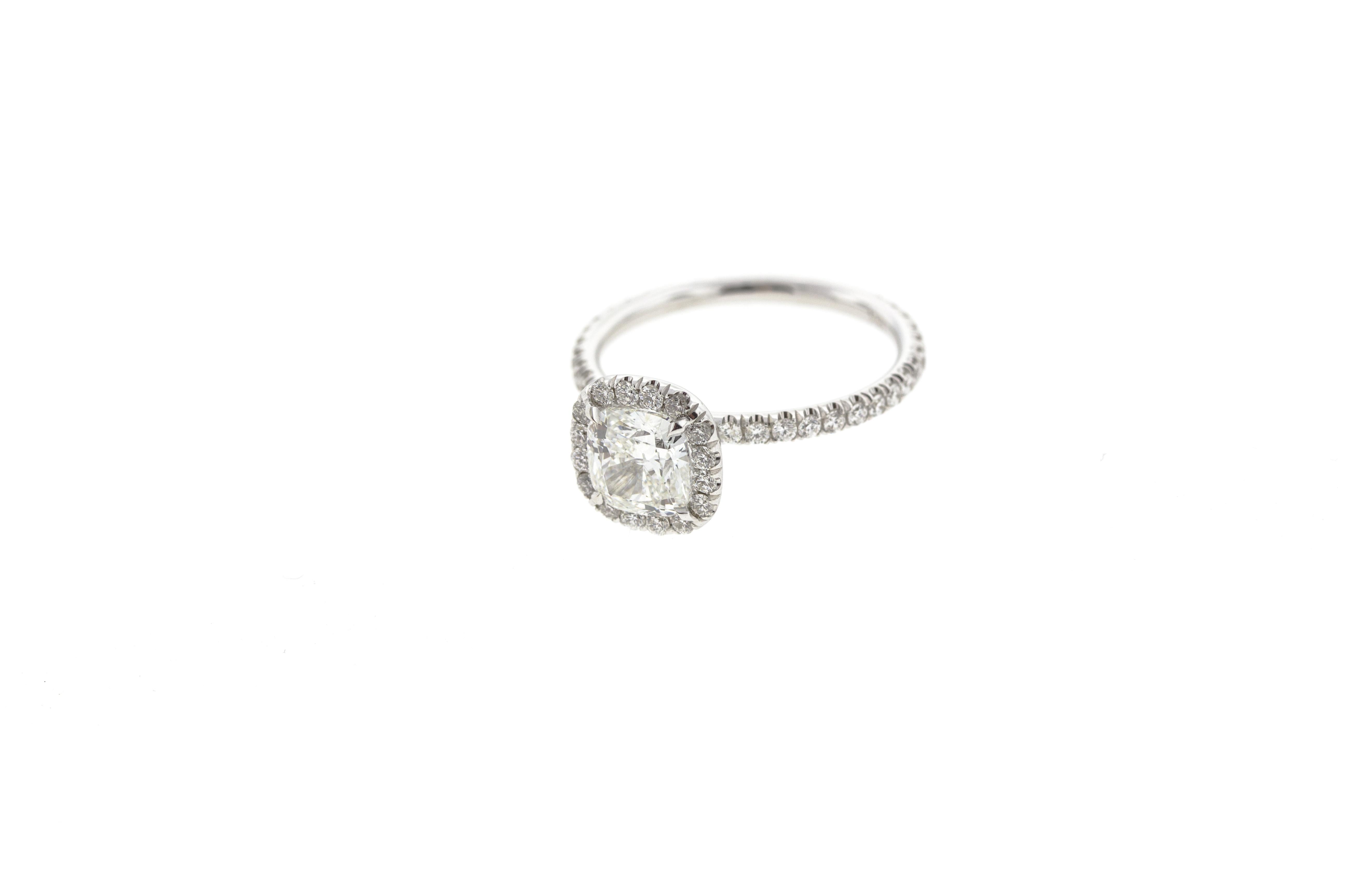 This stunning round diamond engagement ring has a built-in (raised) setting and features a gorgeous diamond cushion-shaped halo and diamonds on the shank. It's one of our most popular style of ring and for a good reason: this classic engagement ring