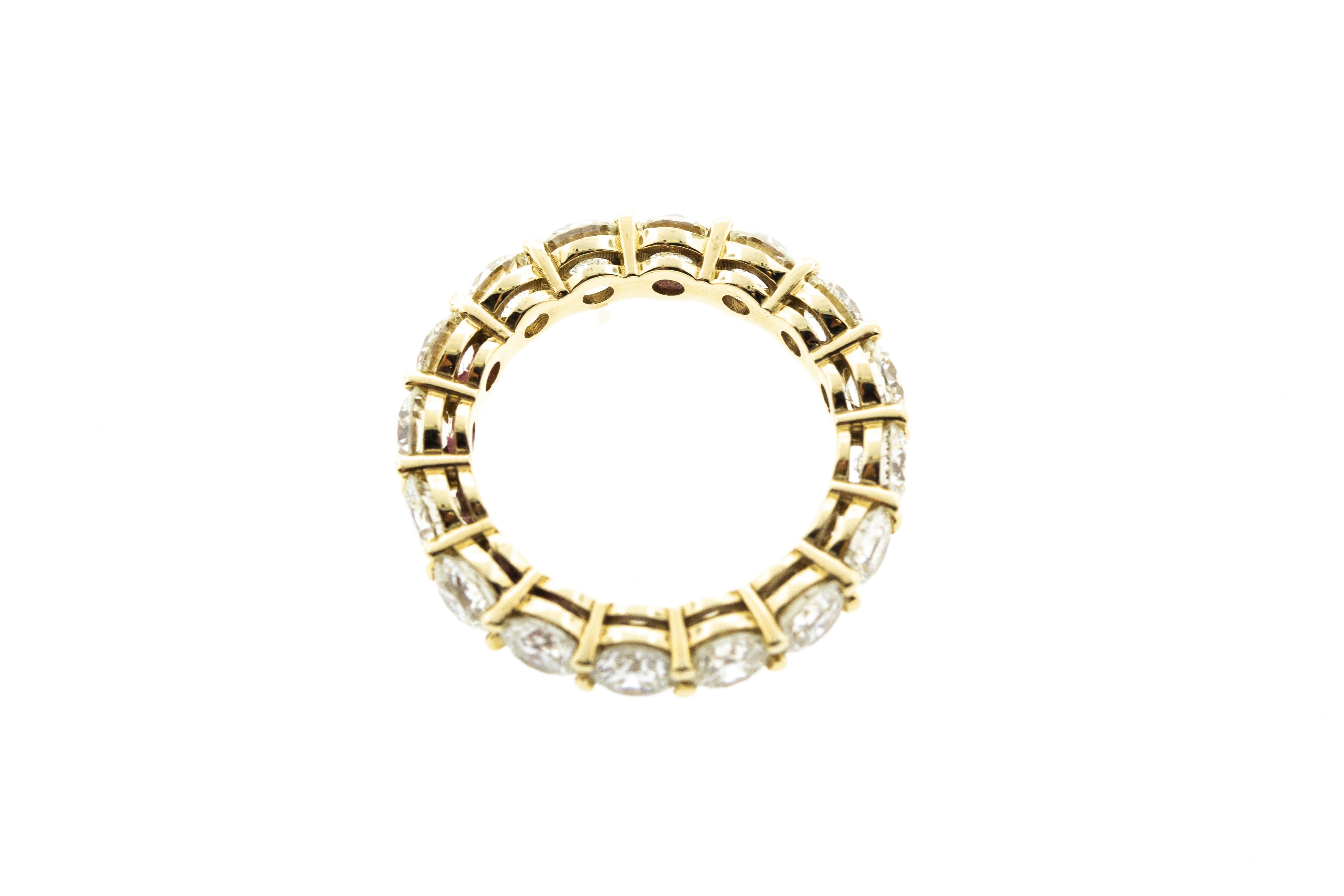 This round diamond eternity band is set in yellow gold and features a shared prong setting. 16 round diamonds are included for a total carat weight of 4.11. 