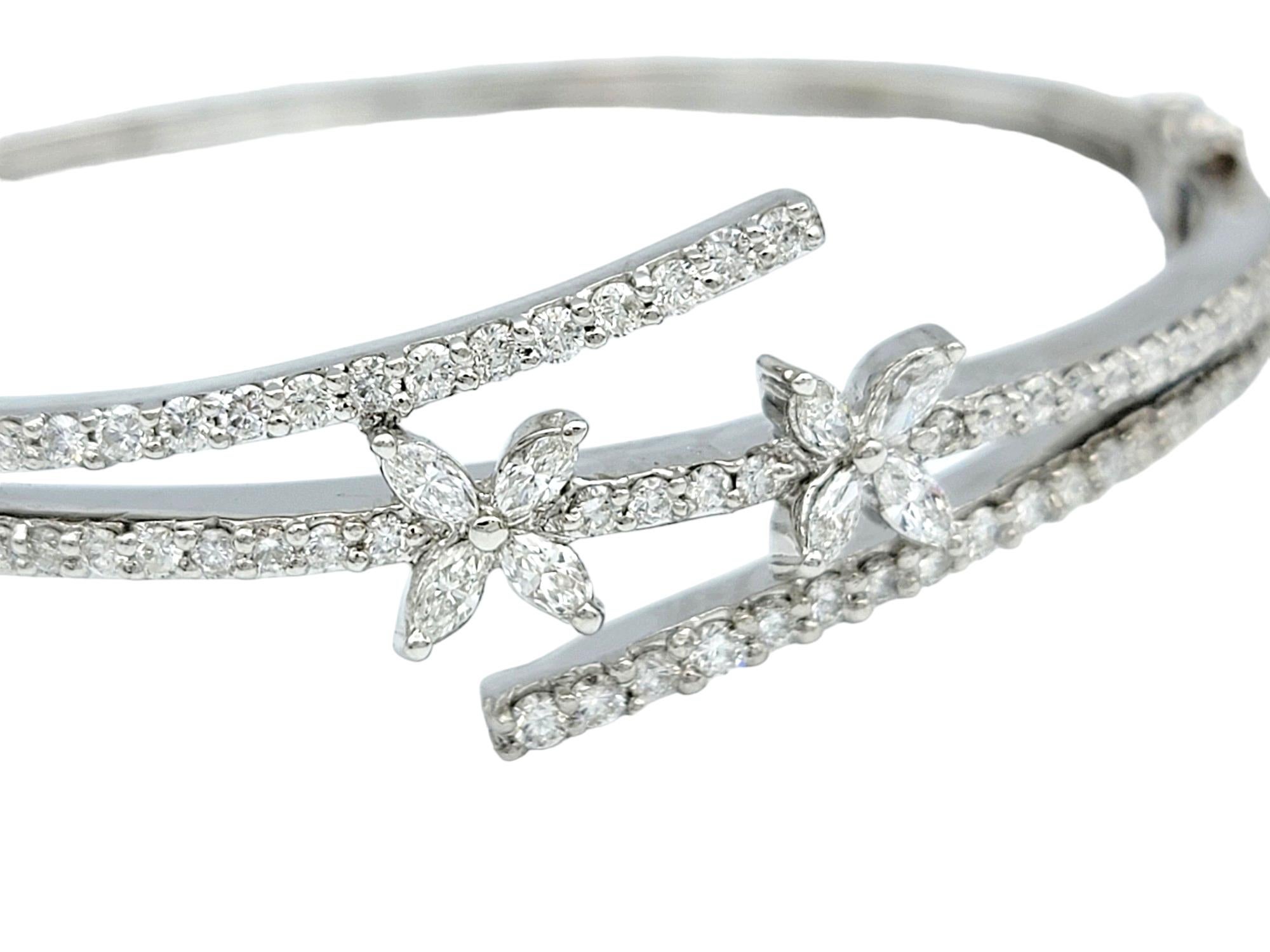 This gorgeous diamond bangle bracelet, crafted in luxurious 18 karat white gold, exudes elegance and sophistication. Designed in a bypass style, the bracelet features a unique arrangement of marquise diamonds arranged in a pretty flower formation,