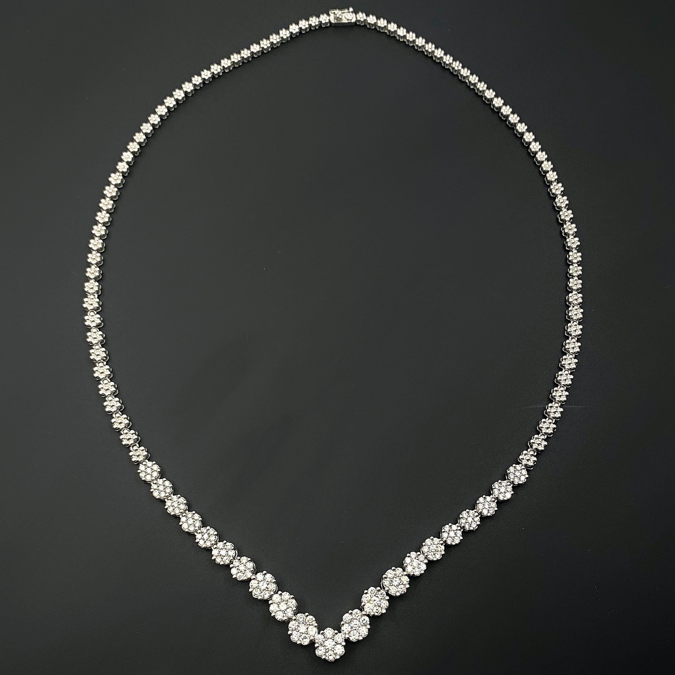 Diamond Flower Contoured V Tennis Necklace
Style:  Contoured
Metal:  14kt White Gold
Length:  18' inches 
TCW:  4.00 tcw
Main Diamond:  147 Round Brilliant Diamond 4.00 tcw
Color & Clarity:  G - H / SI2 - SI3
Hallmark:  14K
Includes:  Certified