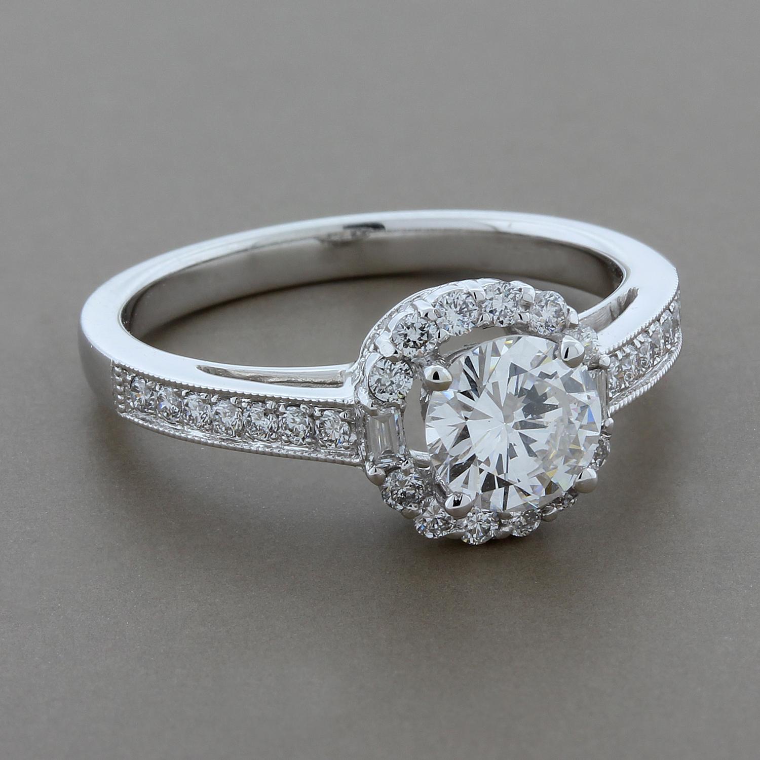 A sweet engagement ring featuring a round cut 0.71 carat diamond at the center.  The spectacularly bright white diamonds boast VS clarity and G color.  It is haloed by round cut and baguette cut diamonds in a special design set in 18K white