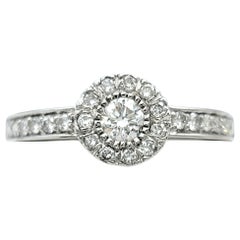 Anillo de compromiso con diamante redondo y halo, en oro blanco de 18 quilates