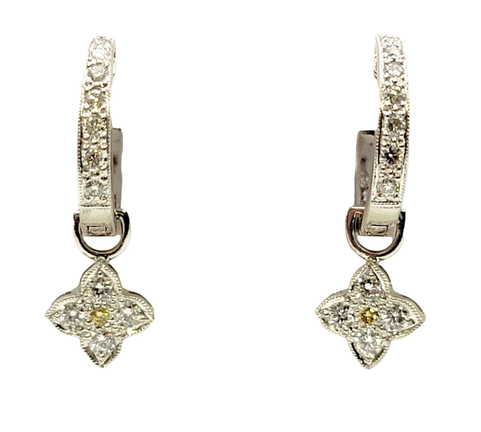 You will love these dainty diamond hoop earrings! Set in polished white gold, the tiny huggie hoops are embellished on the front half with glittering natural diamonds, while a yellow and white diamond drop dangles playfully off the bottom. The