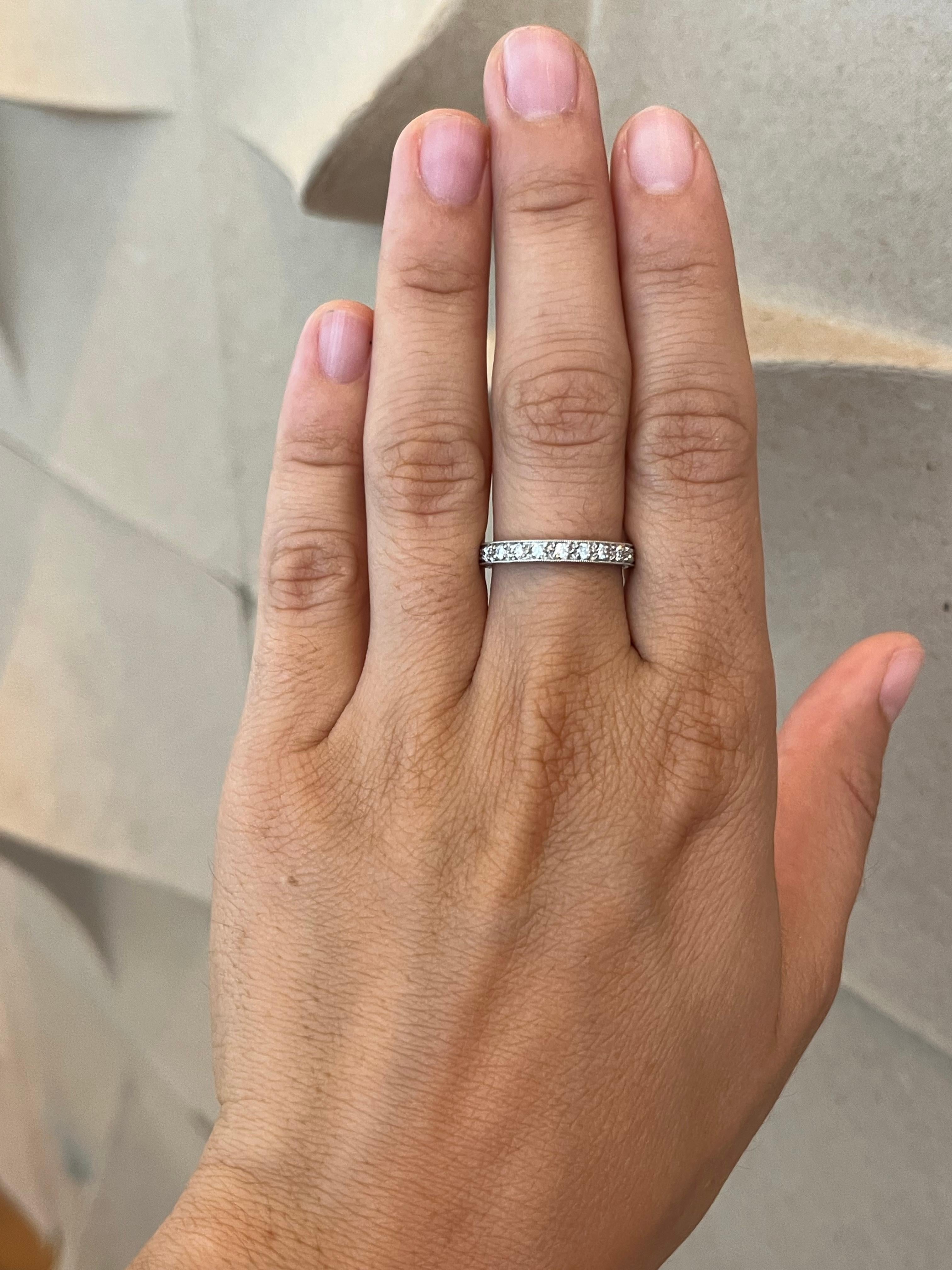 Crafted by Bracken Jewelers in Santa Monica, California. This platinum eternity band is set with 22 bead-set round brilliant cut diamonds that wrap all of the way around and features hand-engraved sides and milgrain detailing. 

- 22 round brilliant
