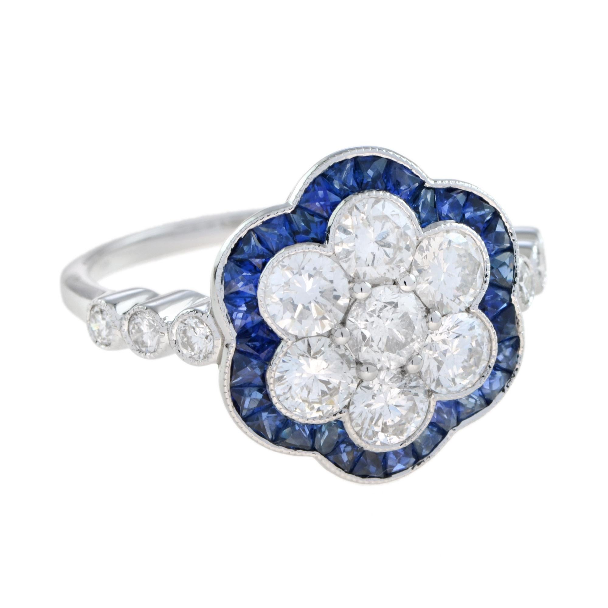 Arte e raffinatezza si uniscono in un anello a fiore con zaffiri e diamanti di ispirazione Art Deco. L'anello presenta un diamante centrale di forma rotonda circondato da zaffiri taglio francese, mentre i diamanti tondi taglio brillante sulle spalle