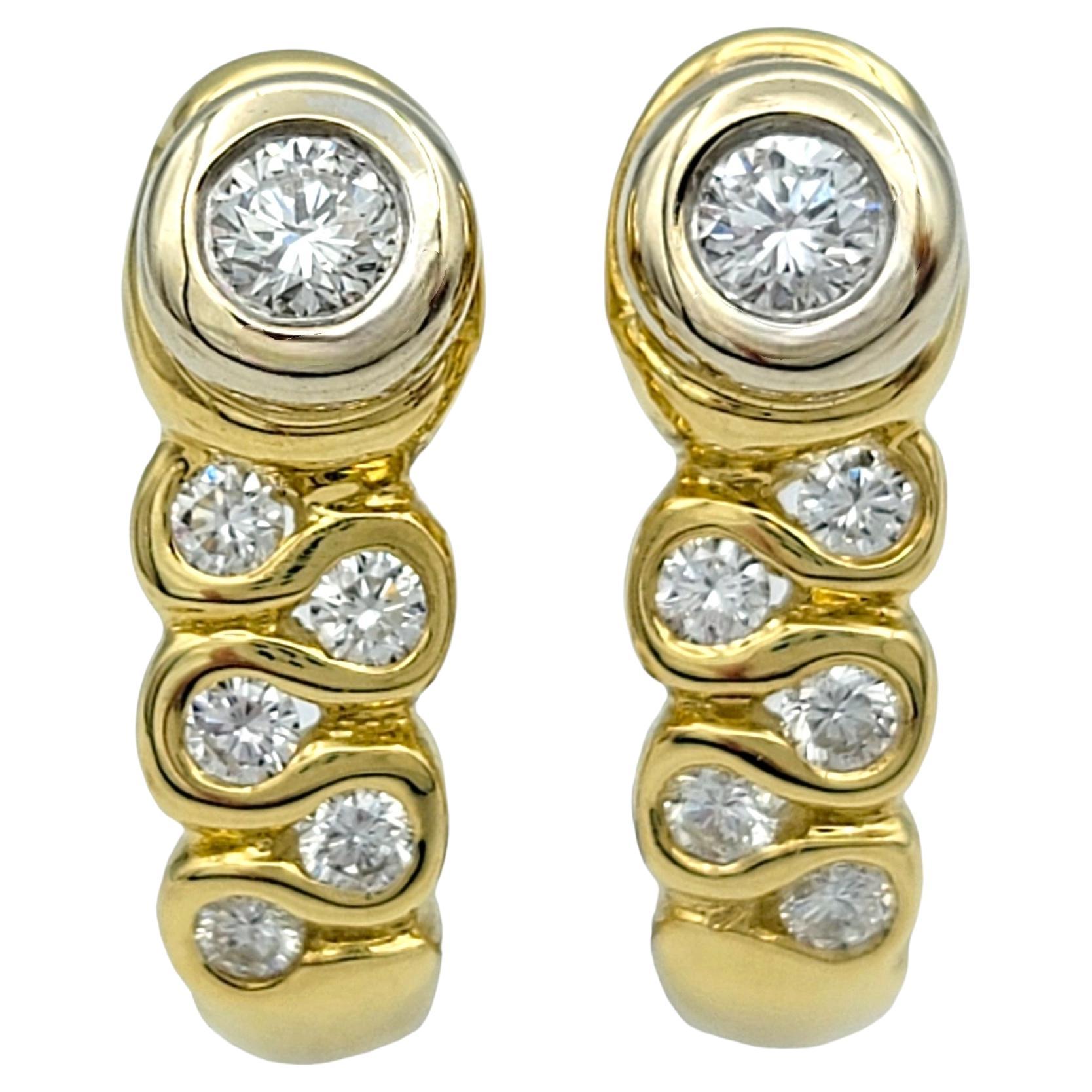 Este hermoso par de modernos pendientes de diamantes presentan cada uno un diseño único de garabatos y están engastados en una combinación de oro blanco y amarillo de 18 quilates. Estos cautivadores pendientes están adornados con brillantes
