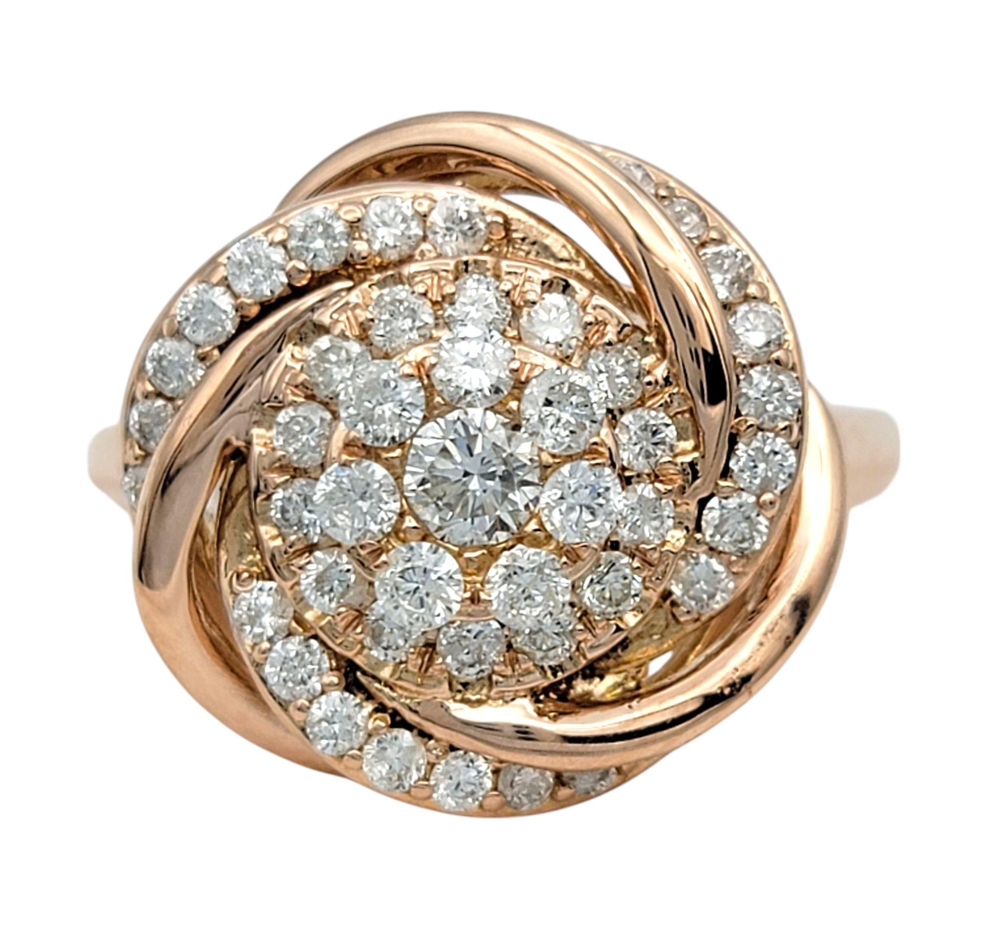 Misura dell'anello: 7

Questo splendido anello presenta un intricato design a vortice ornato da scintillanti diamanti rotondi con taglio a brillante, che creano un punto focale abbagliante. Le curve intrecciate formano un motivo circolare ipnotico