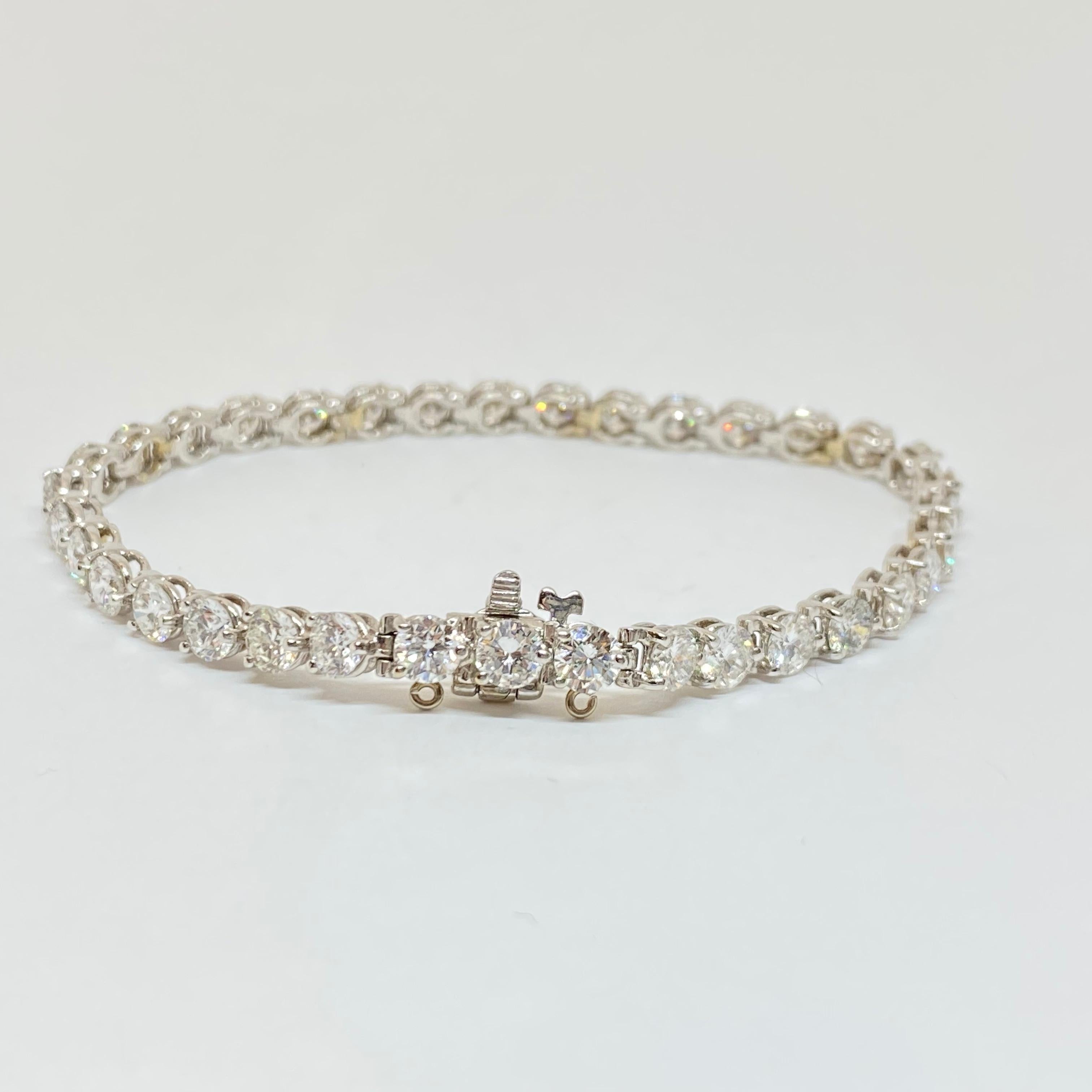 Elegant classic tennis bracelet in like new condition designed in premium 18 karat white gold. Set with round brilliant cut diamonds in three prong settings, attached to a secure box and tongue clasp and safety.  The bracelet measures 4mm wide and
