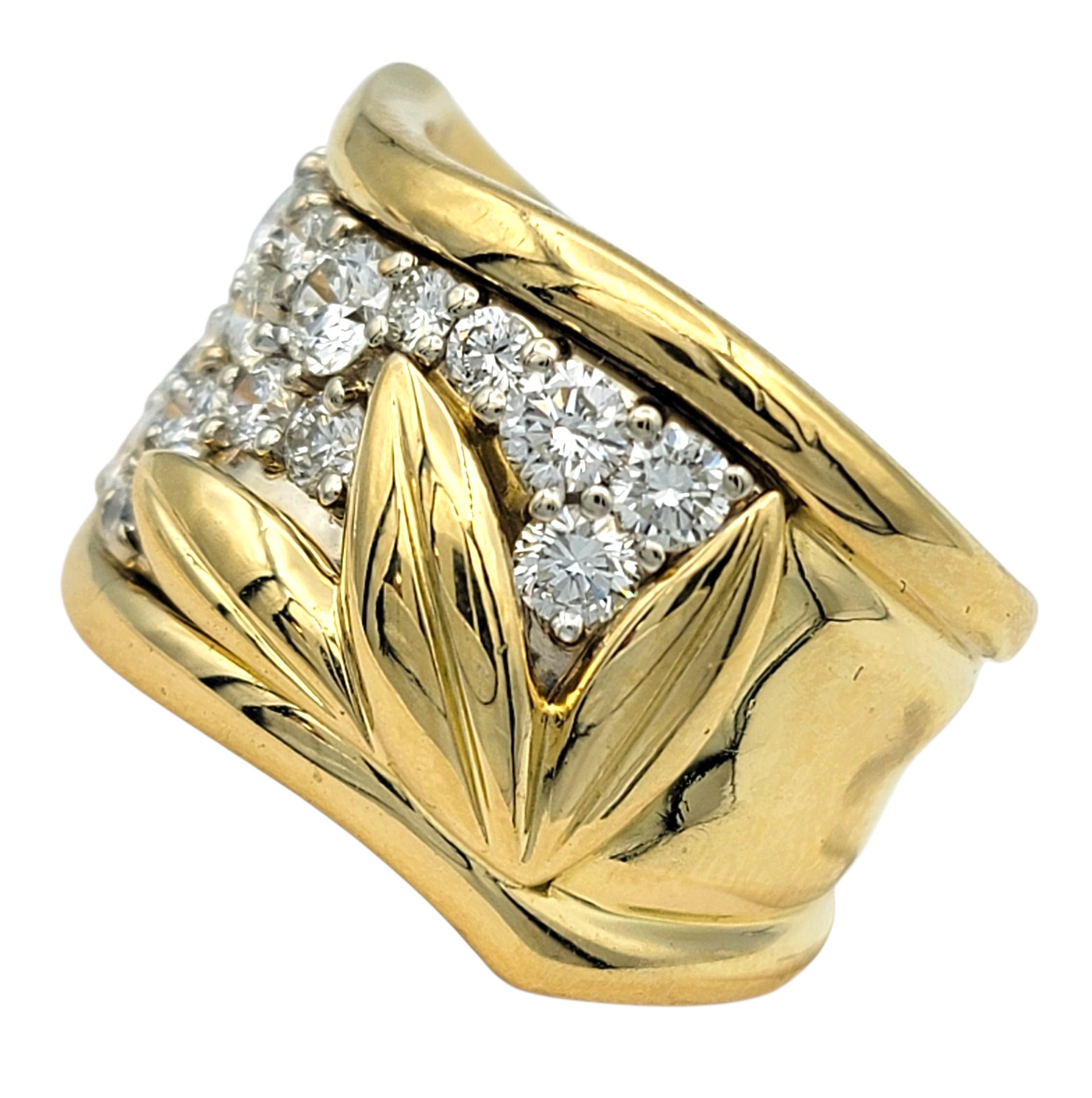 This striking wide band ring showcases a gentle wave design accentuated with a modern leaf design, adding depth and texture to its bold style. Crafted in 18 karat yellow gold, the band features a shimmering array of round brilliant cut diamonds that