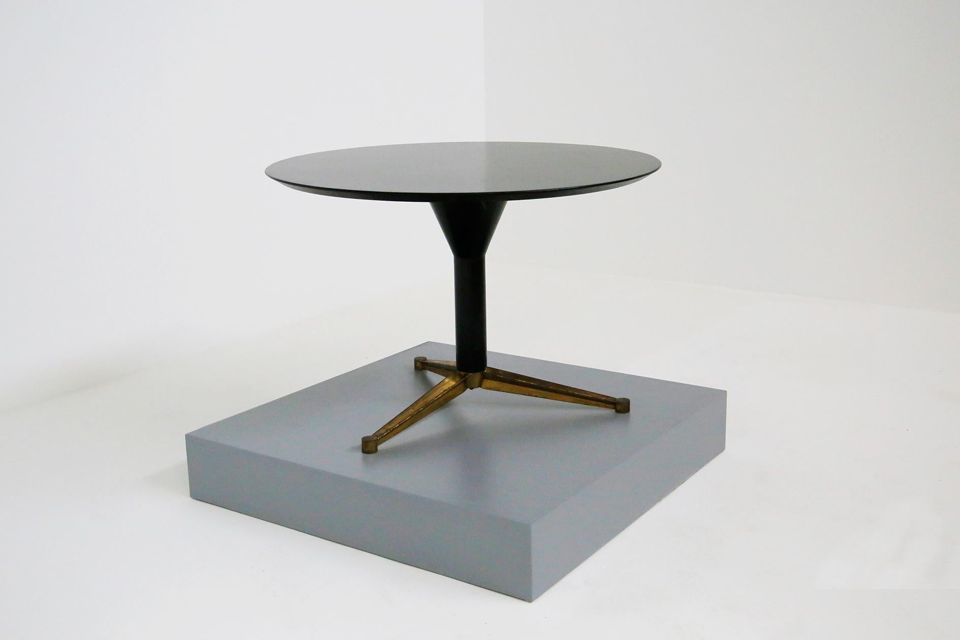 Round table attributed to Melchiorre Bega from the 1950s. The table is in black ebonized wood. Its pendant support creates a harmonious and elegant line with the realization. As a base three star-shaped brass feet are developed under the pendant.