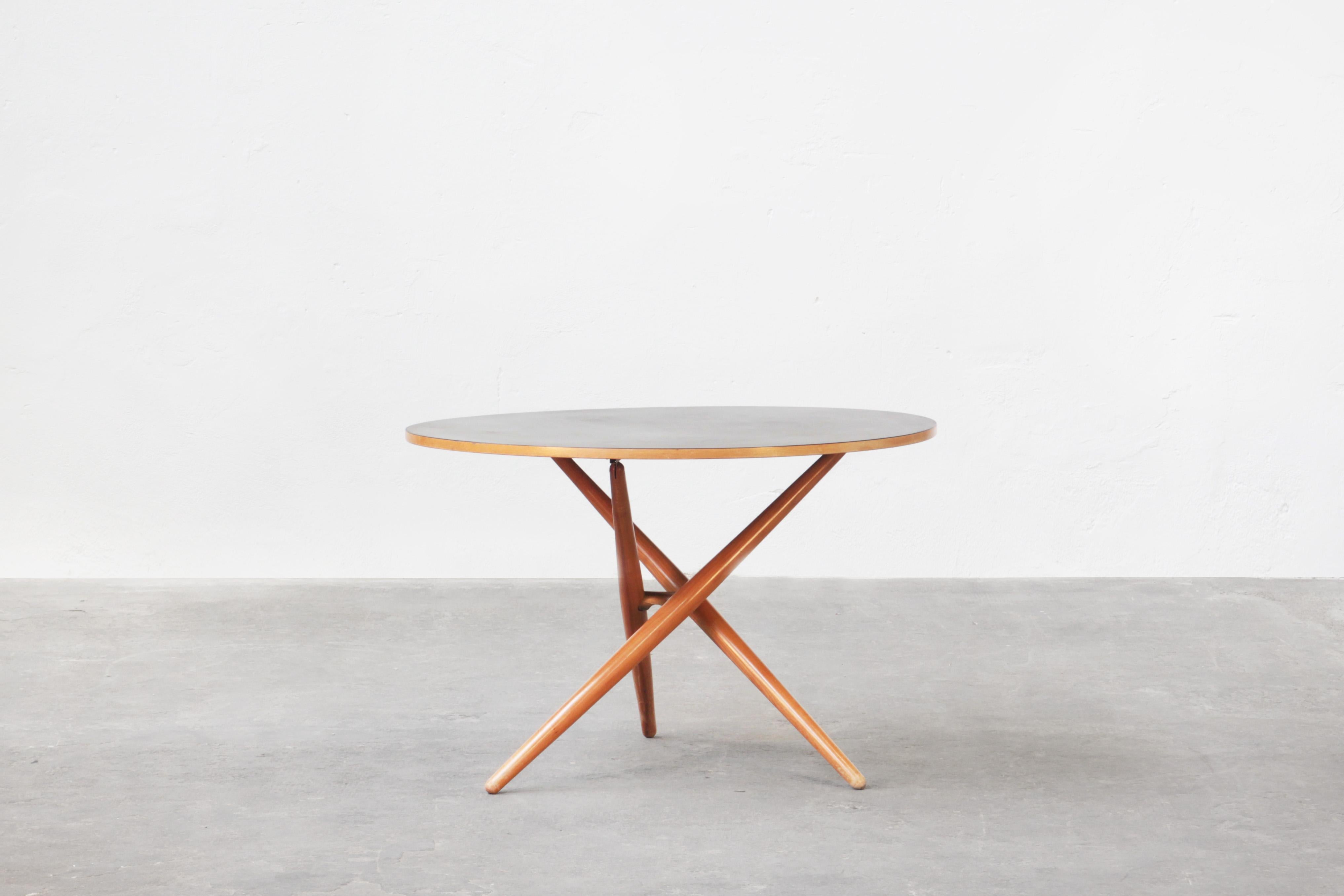An early height-adjustable oak table designed by Jürg Bally for Wohnhilfe, Switzerland, 1951. 
Can be used both as a dining table and as a coffee table.
The black Formica top is still in very good condition and rests on three crossed cherry wood