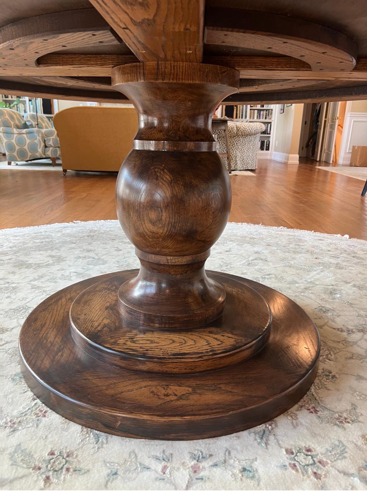 Esta refinada mesa redonda de 1,80 m presenta una sólida base de pedestal y un detallado tablero de parqué de 15 cm. Su llamativo encanto se ve realzado por una profunda pátina de nogal y un acabado ricamente desgastado. De generosas dimensiones,