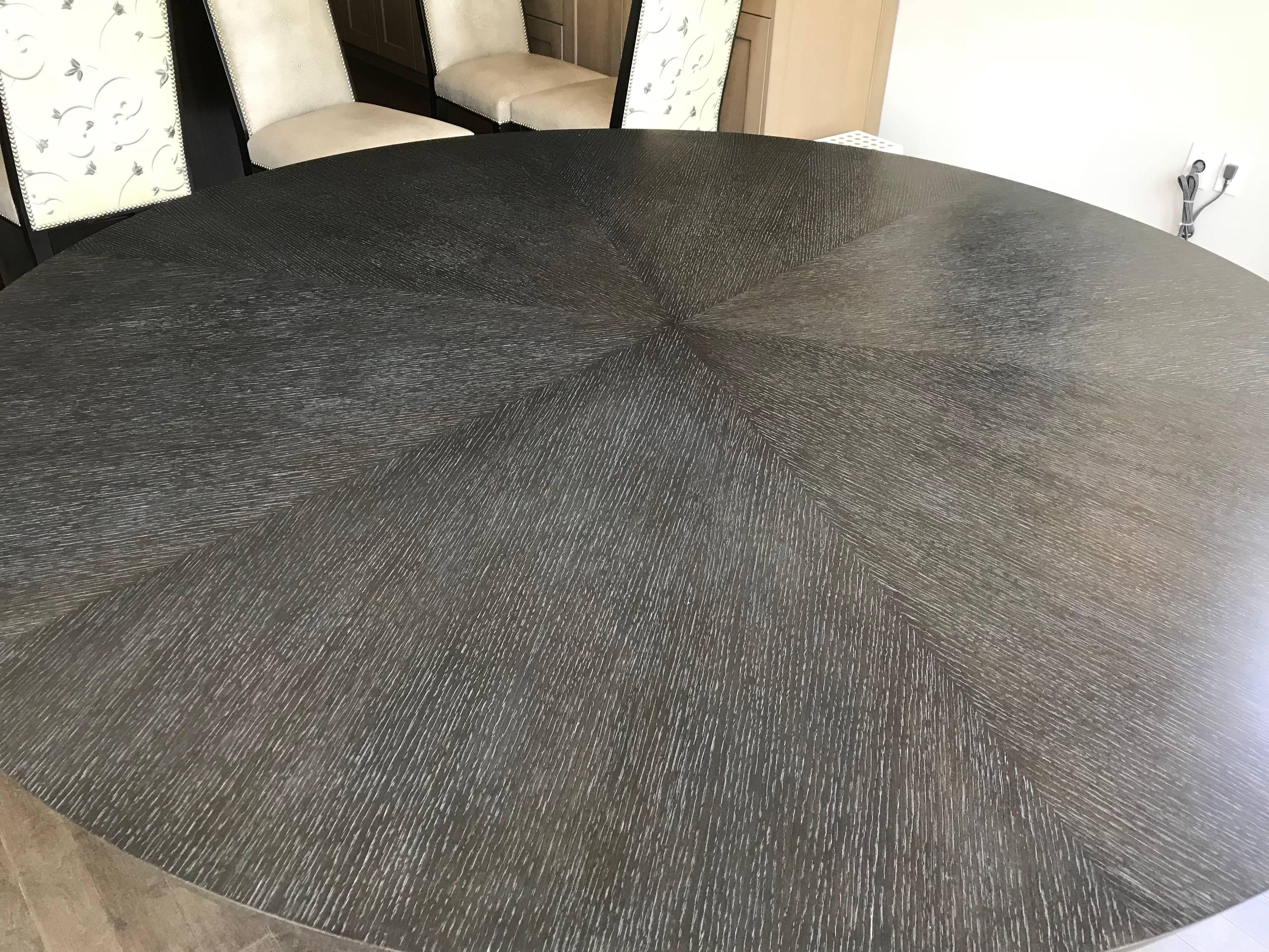 Beautiful 72 inch diameter custom-made dining table made of grey stained rift cut oak. Three columns support the perfectly bookmatched pie shape top. Included in the purchase is a 36