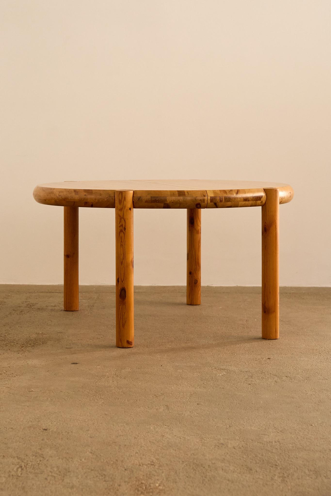 Round pine dining table by Rainer Daumiller, featuring a solid thick top with rounded edges and cylindrical legs that slot seamlessly into the tabletop. Daumiller’s work is celebrated for its sculptural simplicity and use of natural pine,