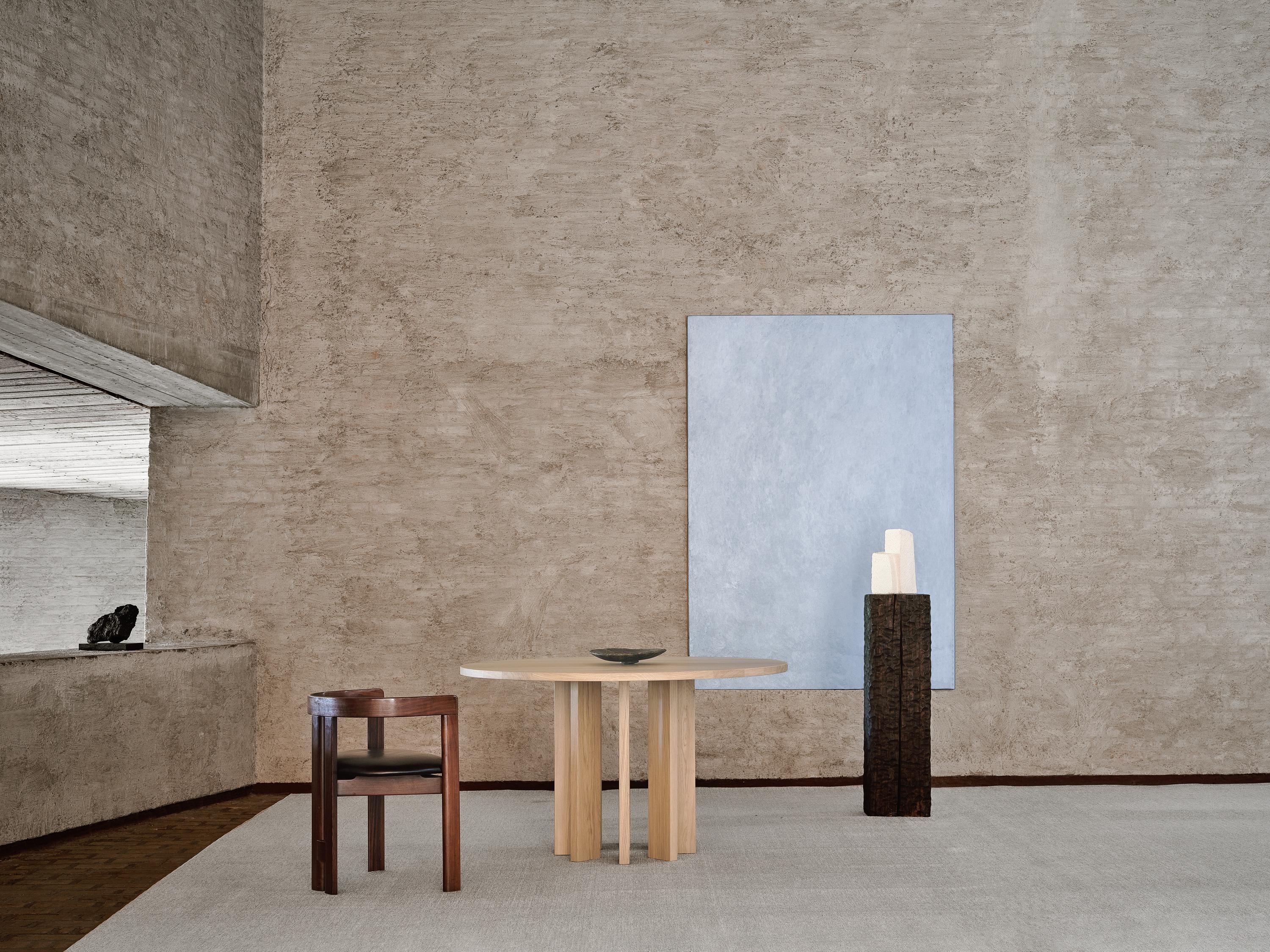 The vertical pillars of the Thola Table form a continuous circular base, creating a​ grounded yet dynamic architectural foundation. The Thola Table plays with light and shadow, creating a sense of quiet monumentality. Its vertical elements shift in