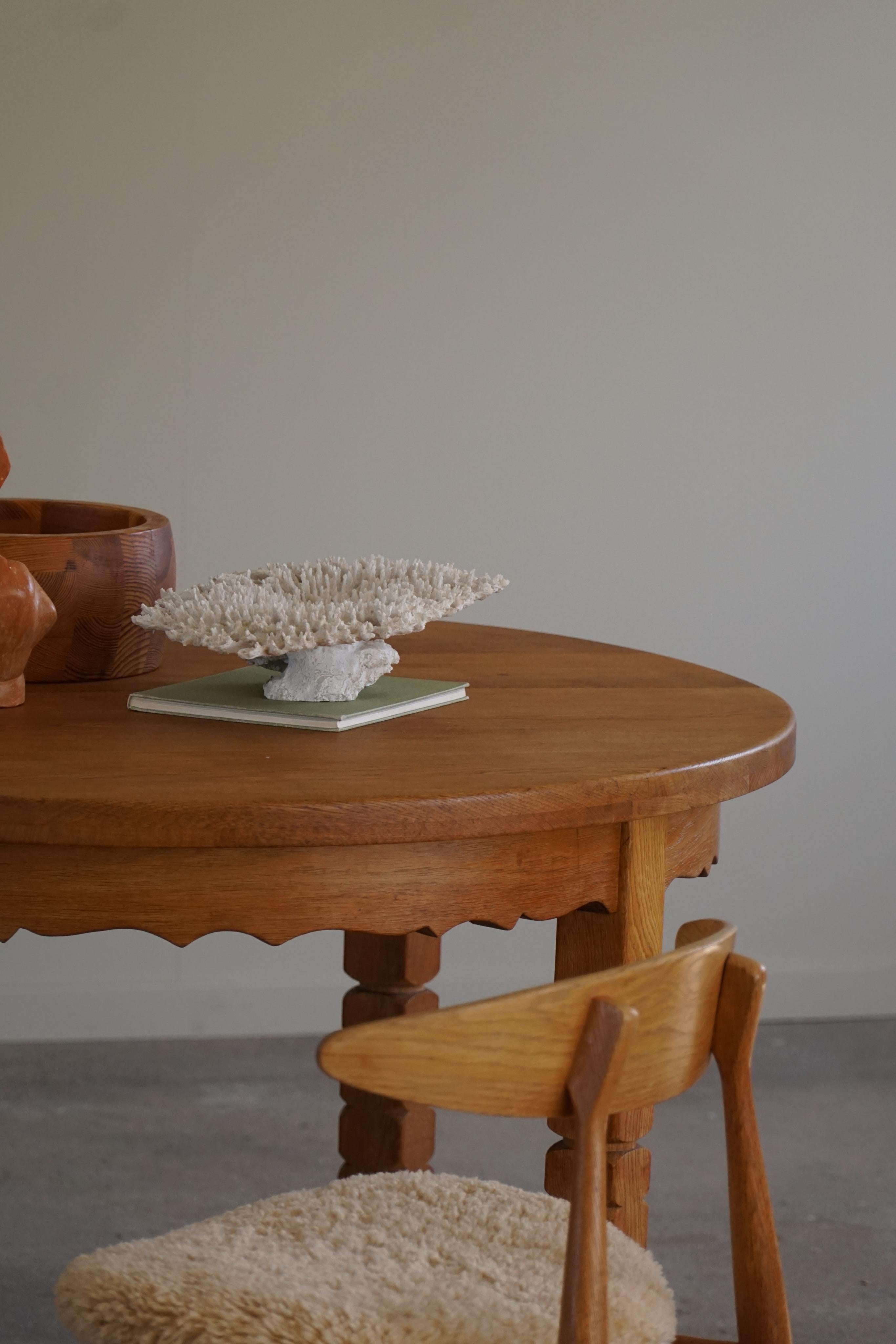 Classic round dining table in solid oak with two extensions, made in 1960s by a Danish Cabinetmaker. Such a sculptural figure for the modern interior.

Curved legs and great craftmanship in this brutalist table. 
Light signs of wear on the