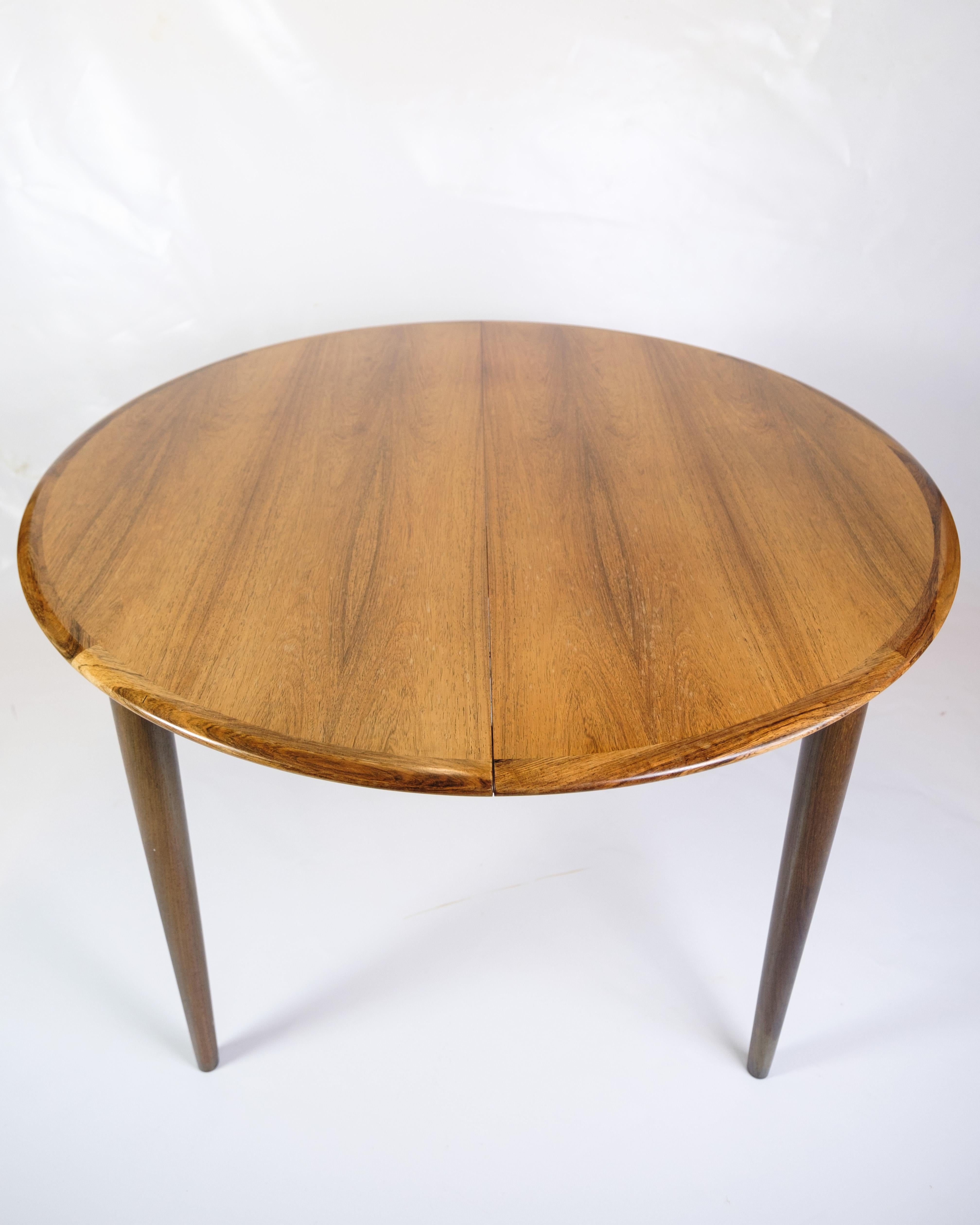 This round dining table in rosewood is a classy example of Danish design from the 1960s. The furniture was created by the renowned furniture designer Arne Vodder, who is known for his simple and functional approach to design.

The table is made of