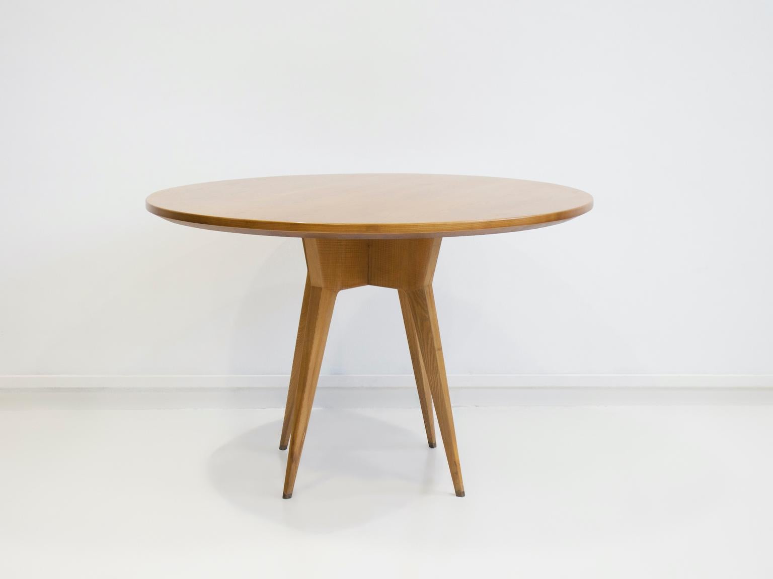 Round table from the 1950s, Italy, made of ash wood. Design in the style of Gio Ponti. Four legs with brass socks. Slight marks on wood on the feet.