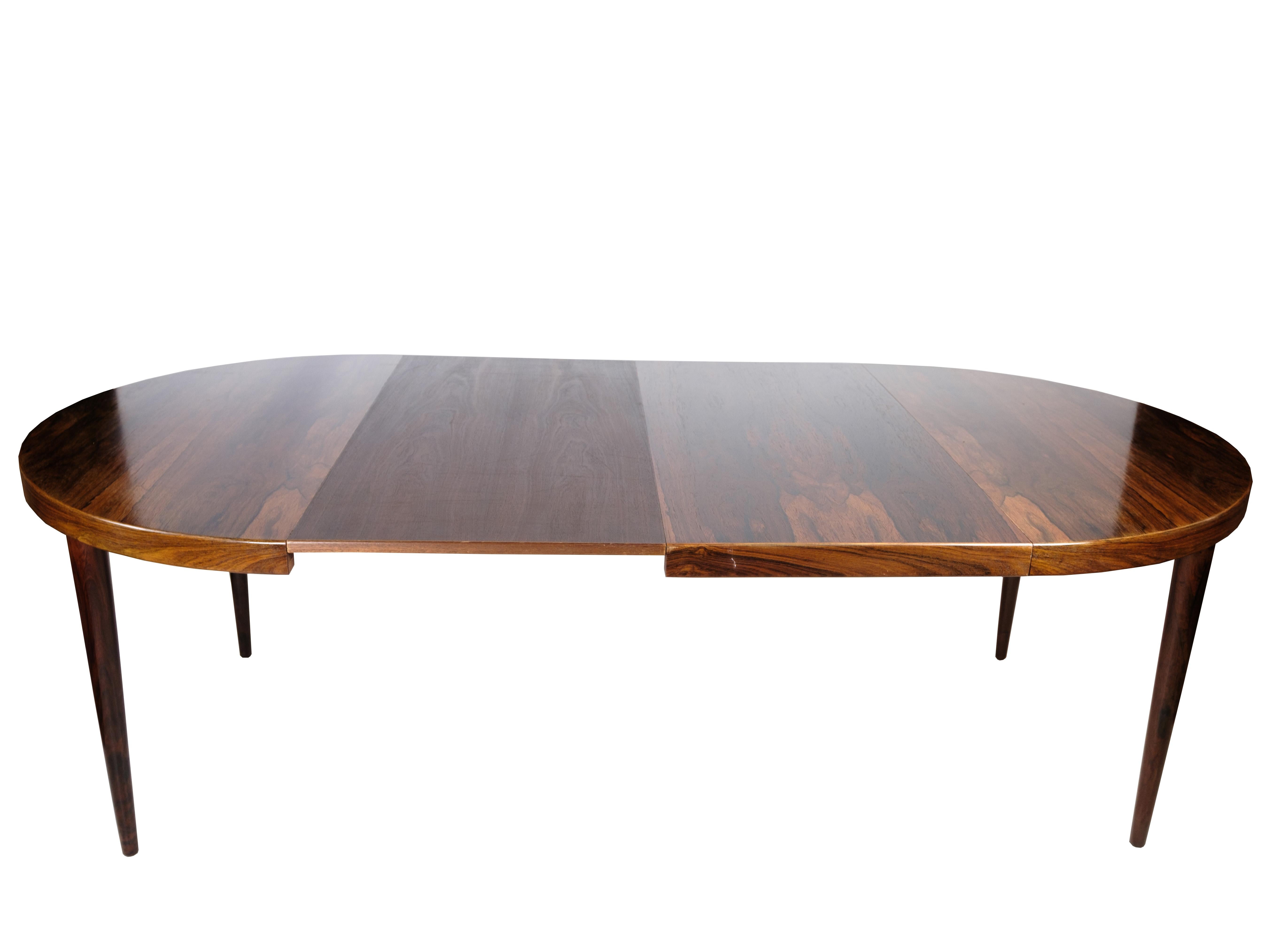 A round dining table crafted in rosewood by Omann Junior, showcasing Danish design excellence from the 1960s. This elegant piece features easily removable legs and a beautifully structured tabletop, adding a touch of sophistication to any dining
