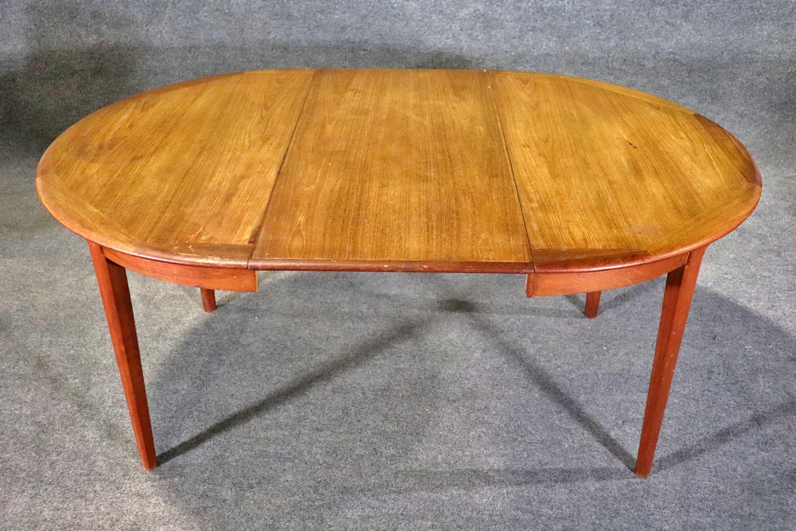 Danish made mid-century modern dining table with leaf. Warm teak grain throughout, with an attractive trim around the top. Leaf is 19