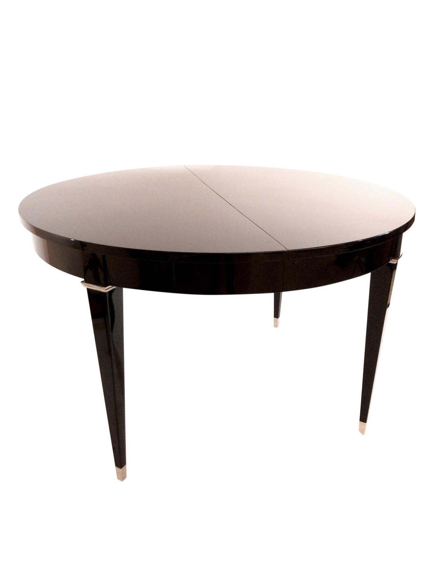 Most dining tables in the Art Deco era were rectangular.
This one is a rare round one.
Black Piano lacquer.
All metal applications are original and fresh nickeled.
The table is capable to extend.