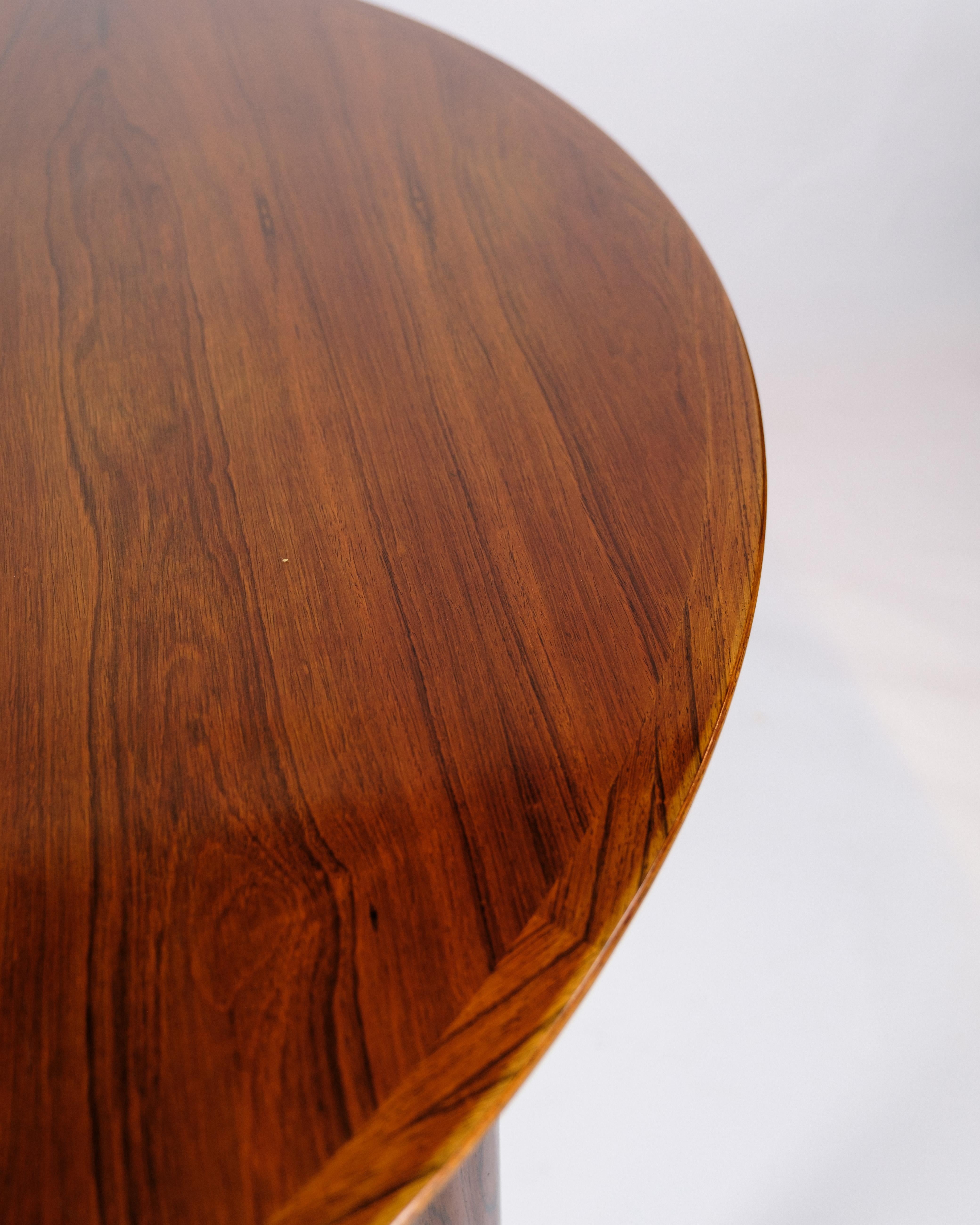 Round rosewood dining table with extension, designed by Arne Vodder and manufactured by Sibast Møbler in the 1960s. The table combines function and quality, with a robust teak construction that gives it a warm and natural glow. The extension leaves