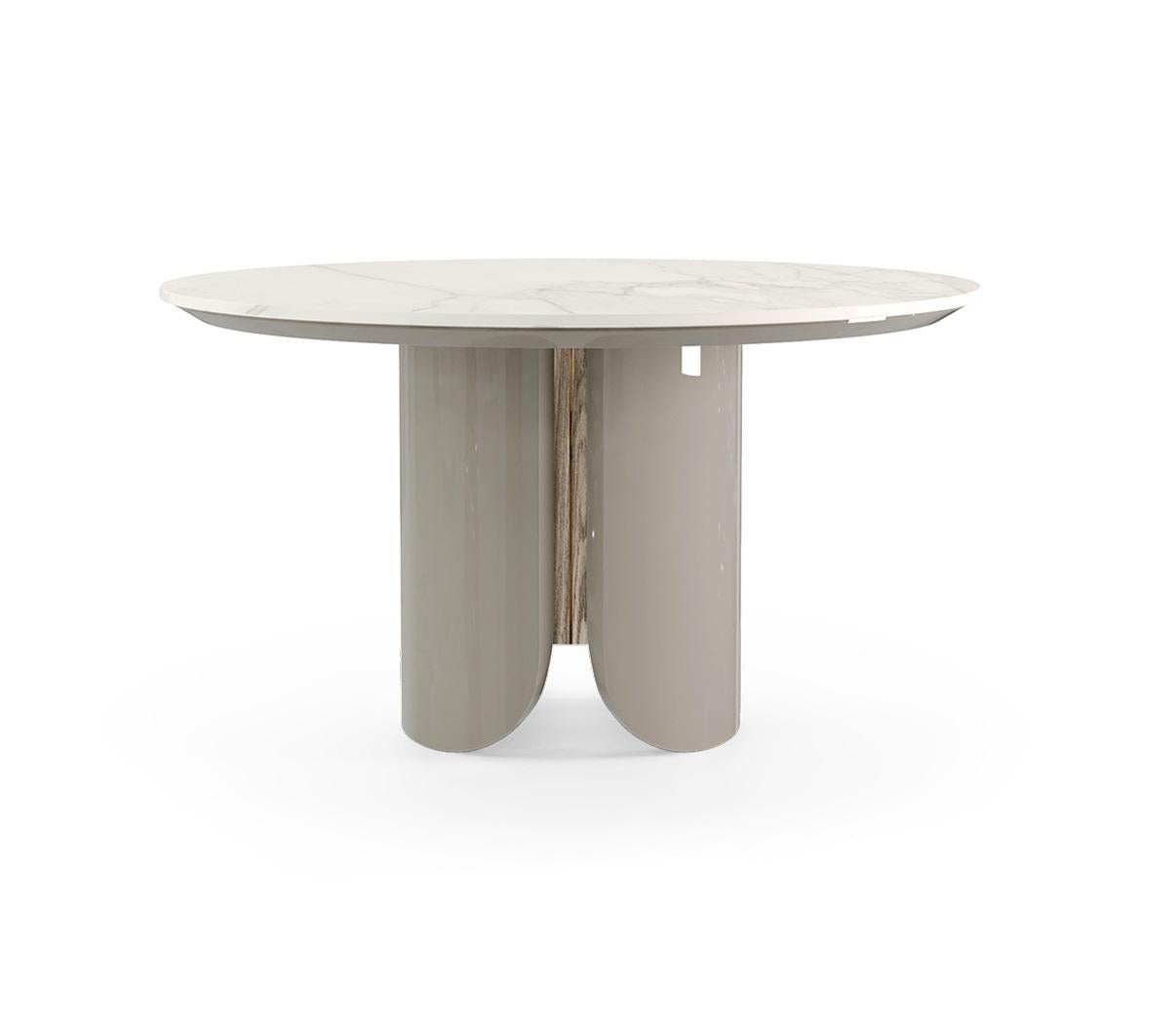 Questo tavolo da pranzo ha un design raffinato e contemporaneo, che unisce materiali lussuosi a un'architettura minimalista. La sua base scultorea è rifinita con una laccatura lucida che crea una base elegante e moderna. Il piano del tavolo,