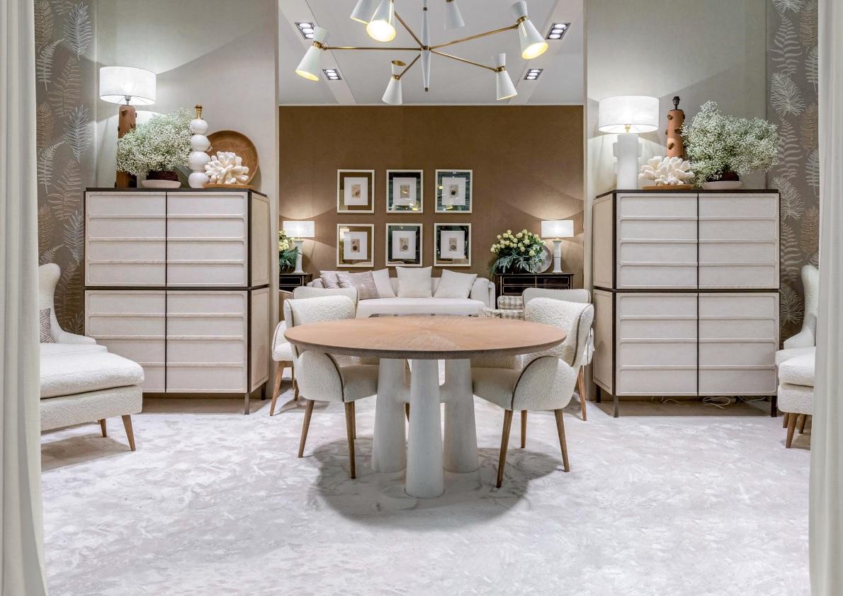 Mesa de comedor redonda con base de tres pilares enlucida y tablero redondeado de madera de roble con acabado cerúleo. Las elegantes curvas evocan una sensación de movimiento y fluidez, desafiando la típica naturaleza estática de los muebles. No es