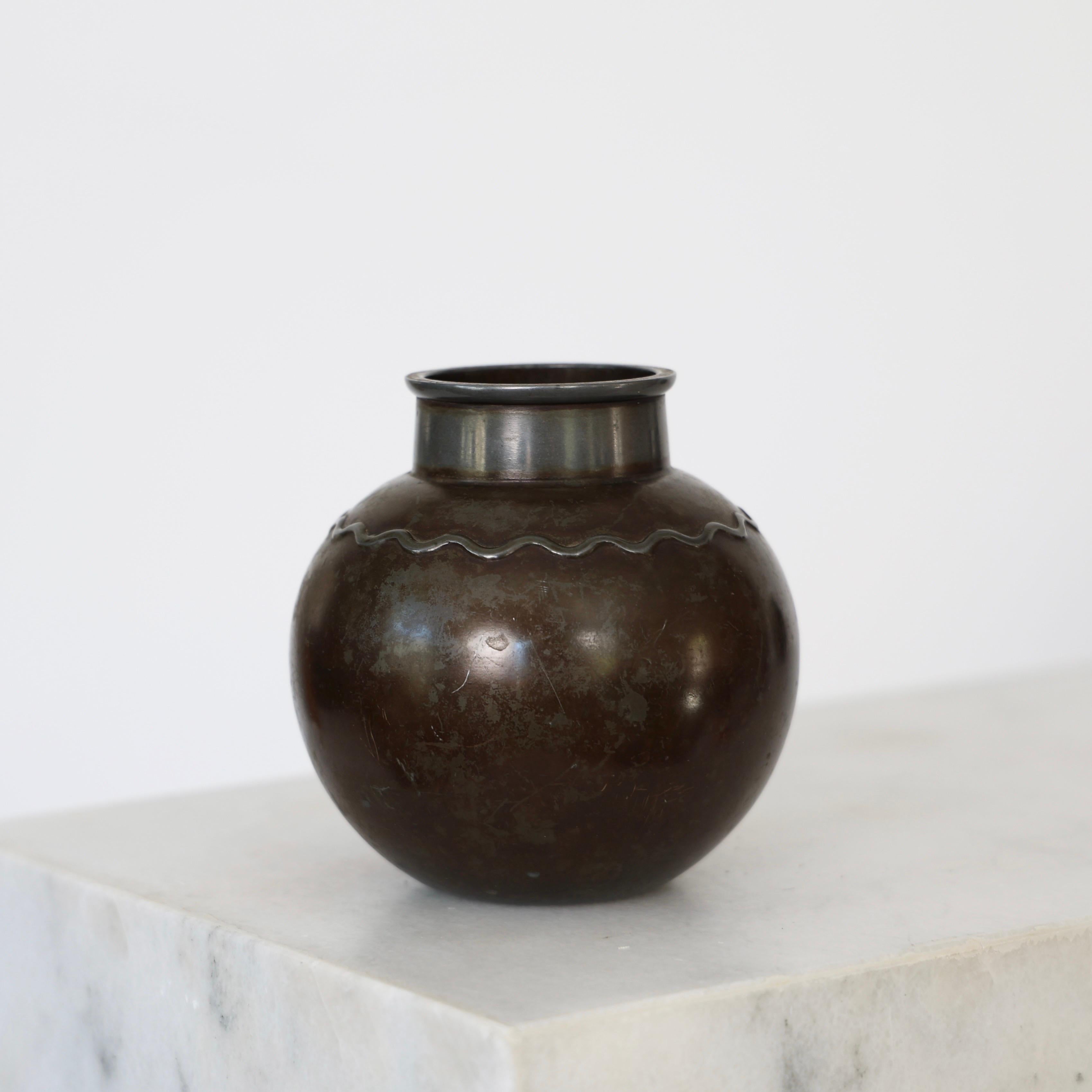 Round Diskometal Vase designed by Just Andersen in the 1930s. A timeless piece for a beautiful place.

* Round diskometal vase with waves
* Designer: Just Andersen
* Manufacturer: Just Andersen Denmark
* Model: D1399
* Condition: Fair vintage