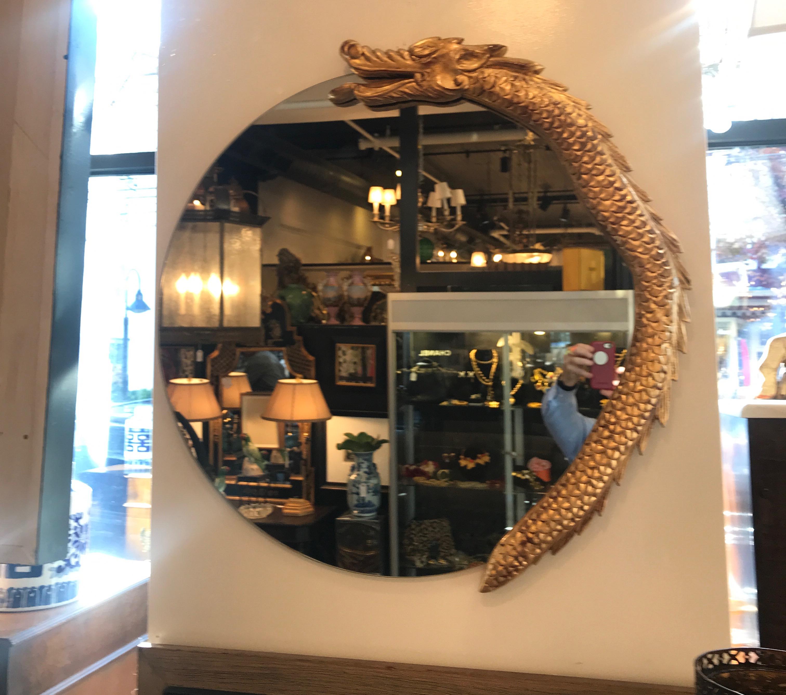 Artist round mirror with giltwood dragon. The mirror with a partial frame of a carved dragon on the on side. Whimsical and unique.