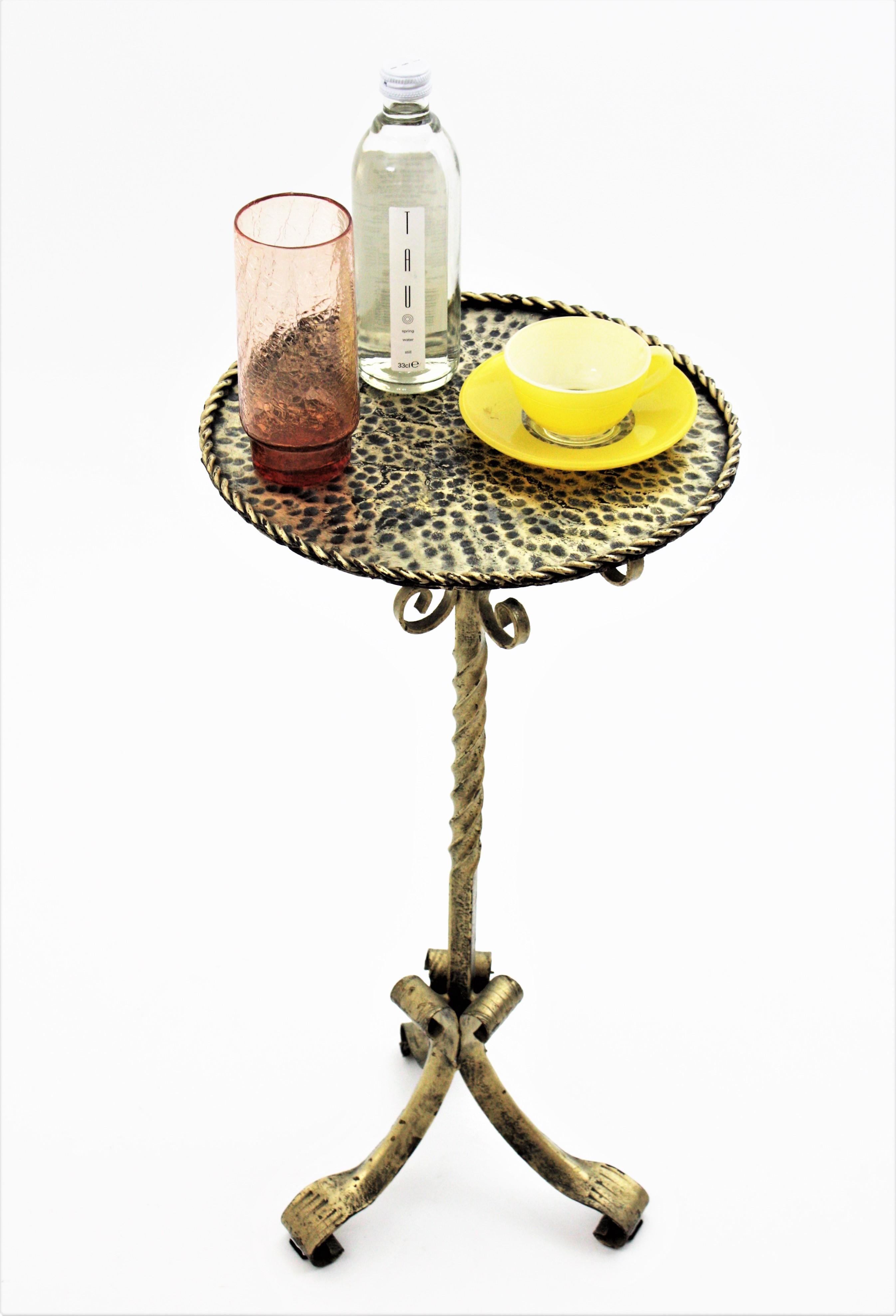 Spanish Silver Gilt Iron Drinks Table Gueridon, End Table or Pedestal standing on tripod base. Spain, 1960s.

An Spanish wrought iron silver-tenue gilt patinated Martini table, stand or drinks table. 
This nice end table has a richly hammered top