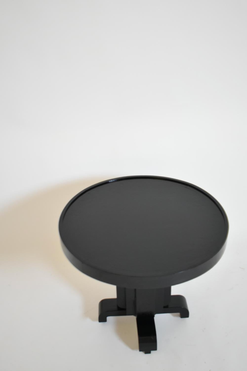 Round Art Deco pedestal table in ebonised wood with a geometric central shaft and resting on four legs. France, 1930s.