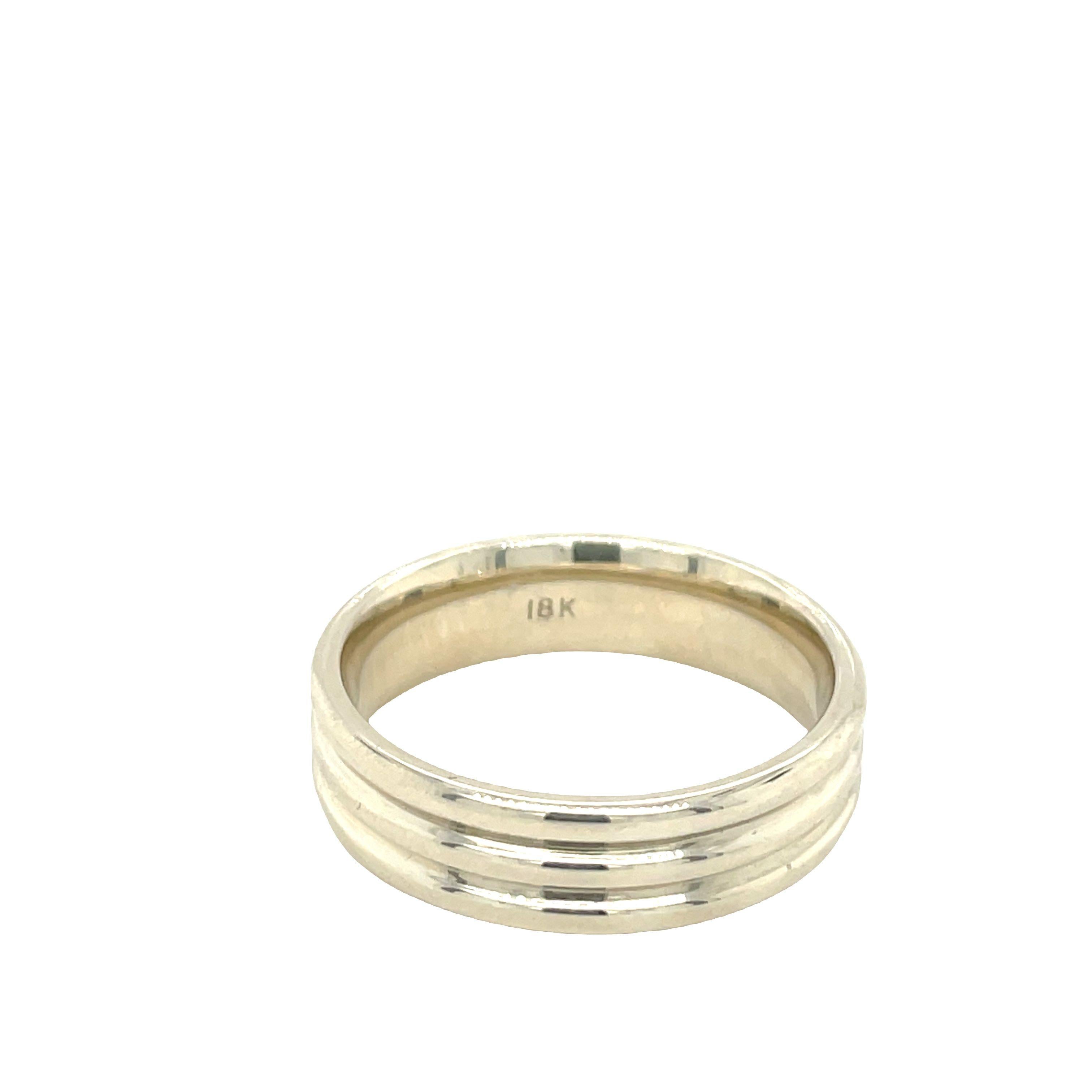 Crafted from 18K white gold, this sophisticated wedding band boasts a contemporary aesthetic with two seamlessly integrated grooves along its outer rounded surface, lending it a sleek and modern profile. The band has been meticulously polished to