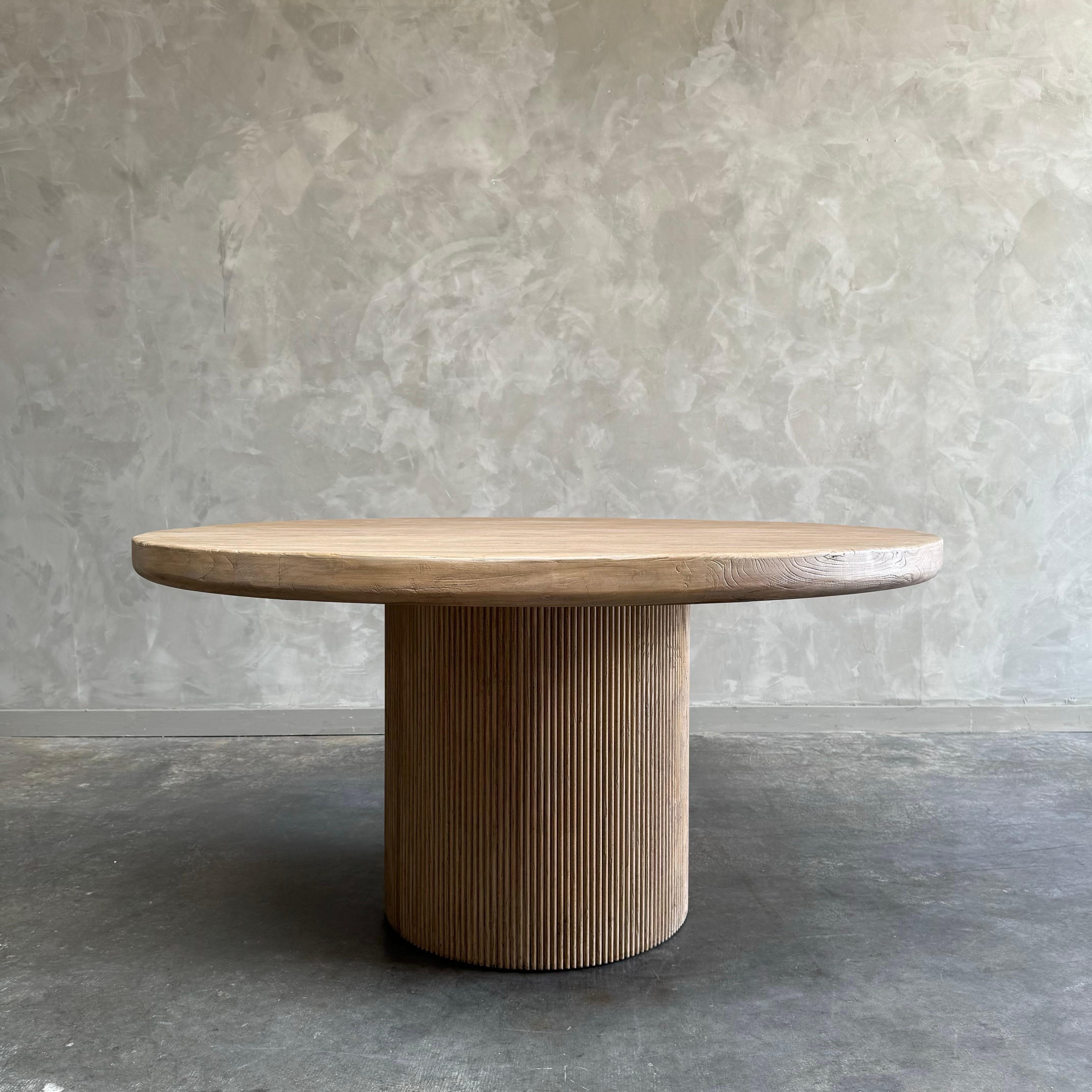 Nori dining table 60”rd. X 30”hWith a fluted column table base, the Nikki Dining Table is a modern minimalist's dream.

Made of solid elm, the table's finish highlights the natural grain and beauty of the wood.

Due to the handmade construction and