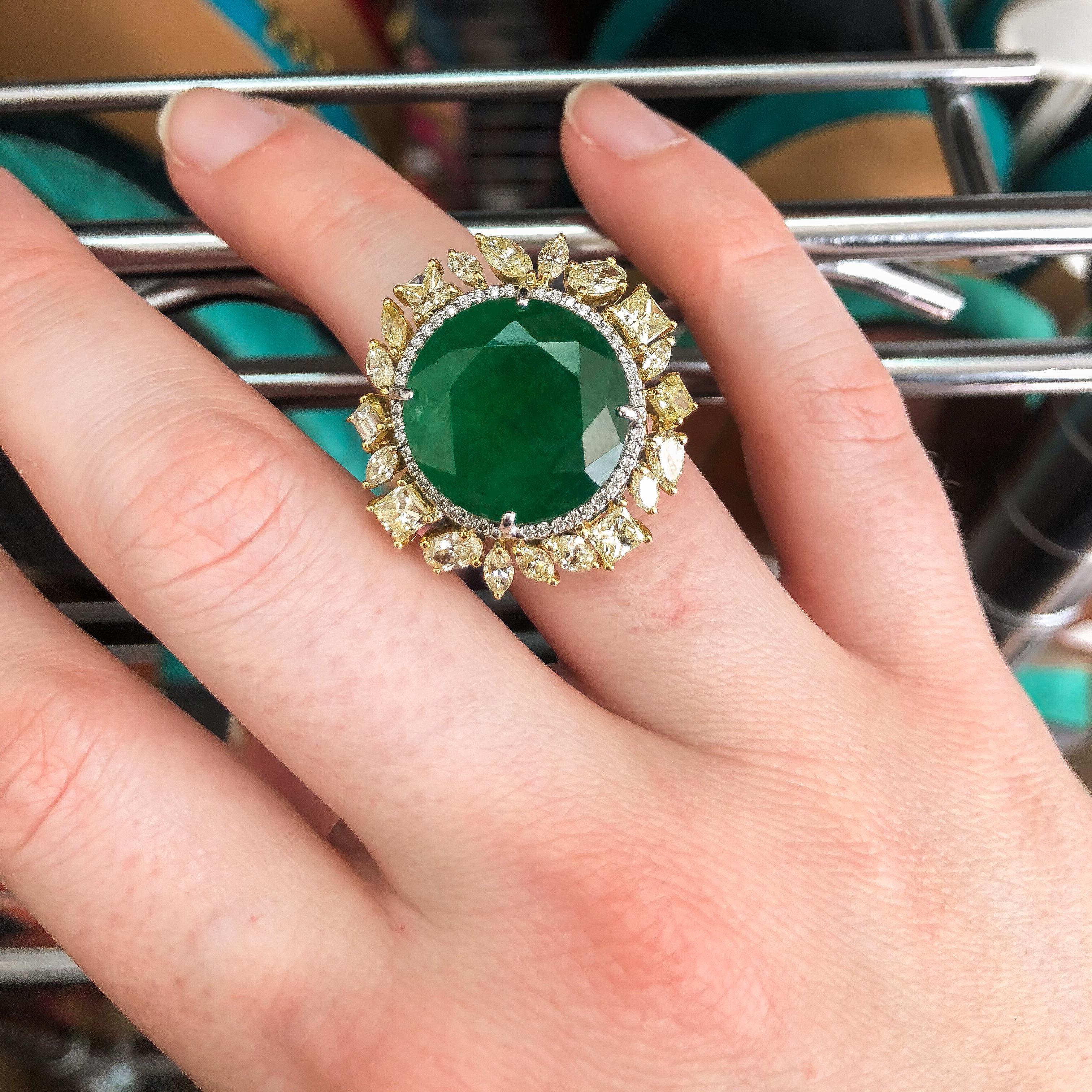 This beautiful cocktail ring features a round cut emerald stone which is rare for this size stone. Vivid Green Color. Features a micro-pave halo with fancy color diamonds around the ring which gives a stunning look to the ring.  
Ring Measurements -