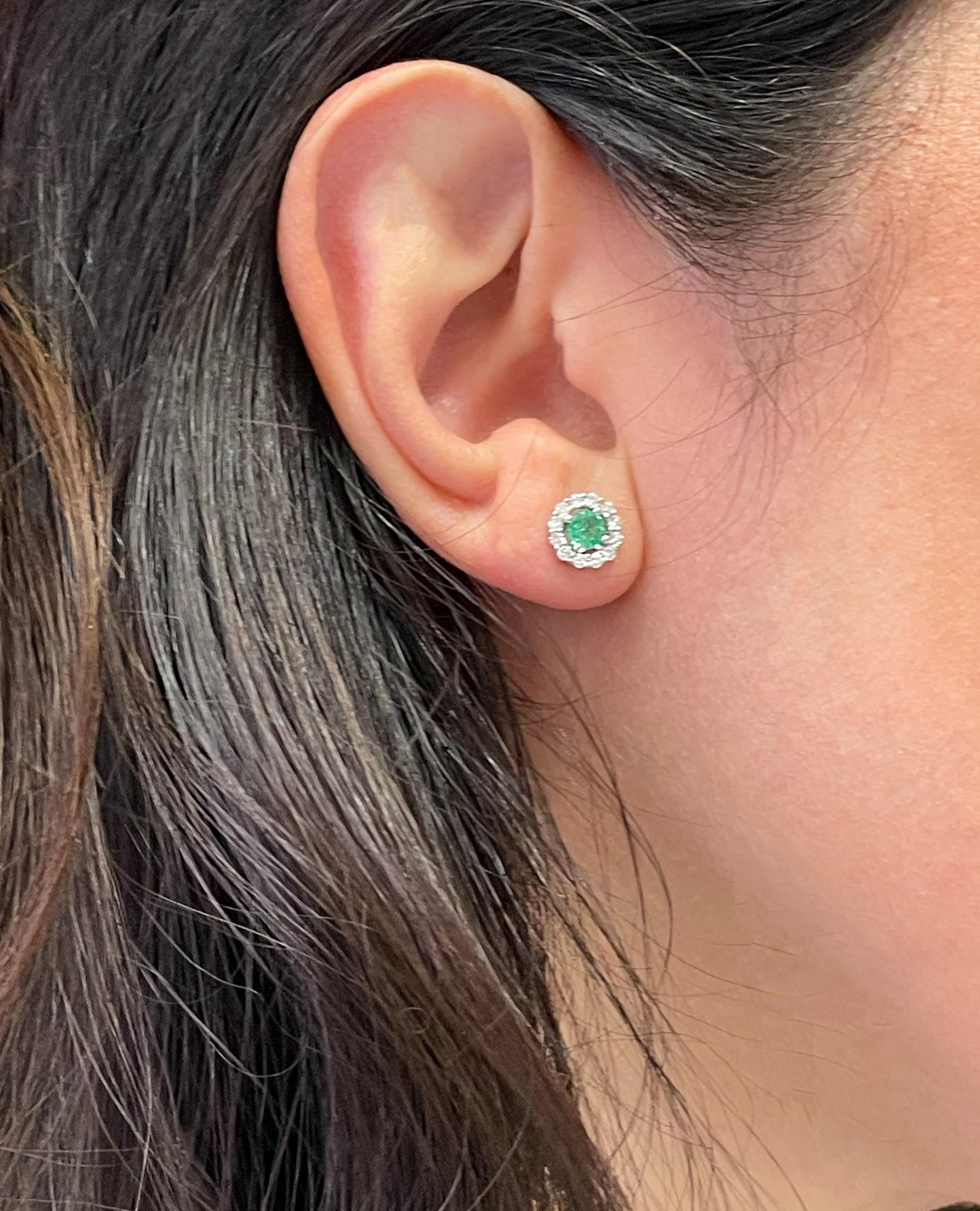 14K white gold stud earrings with 24 round diamonds weighing 0.36 carat total and two round emeralds weighing 0.50 carat total.  