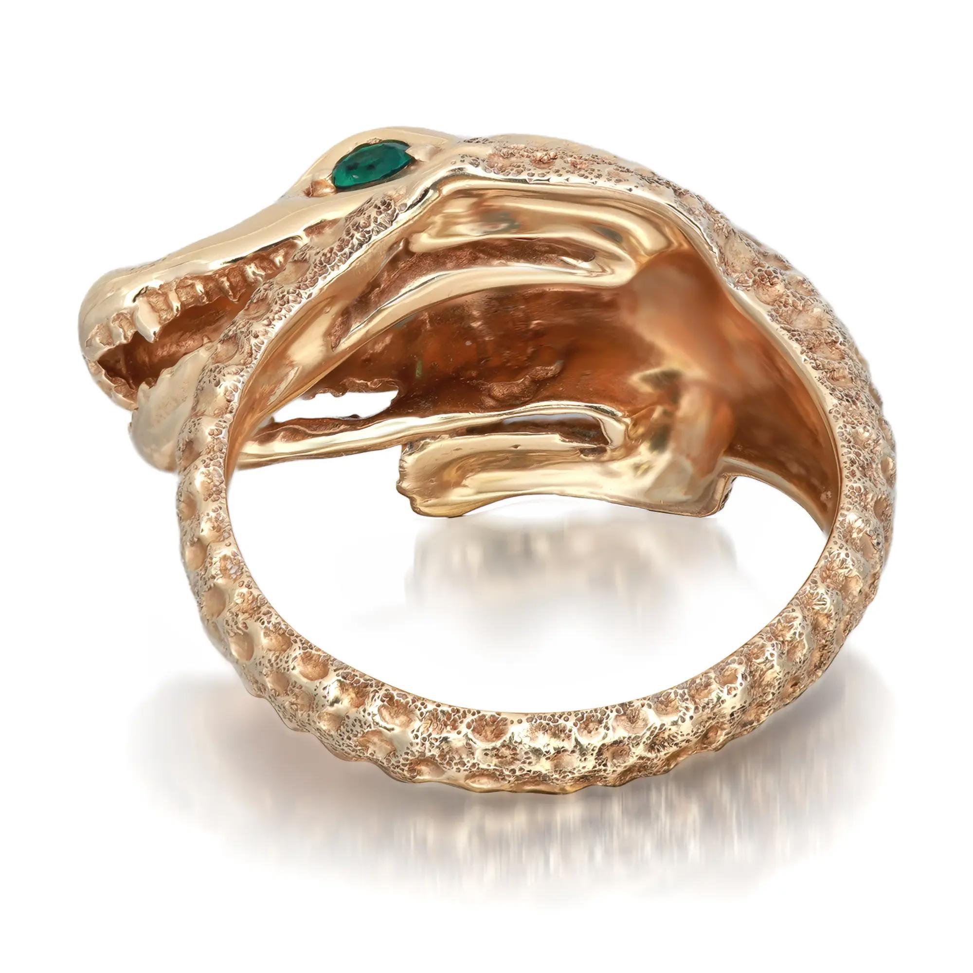 Dieser phantasievolle Ring in Form eines Krokodils, das sich von Kopf bis Schwanz um den Finger wickelt, ist aus 14 Karat Gelbgold gefertigt. Die Augen sind mit rund geschliffenen Smaragden von 0,10 Karat besetzt. Ringgröße: 5,75. Gesamtgewicht: