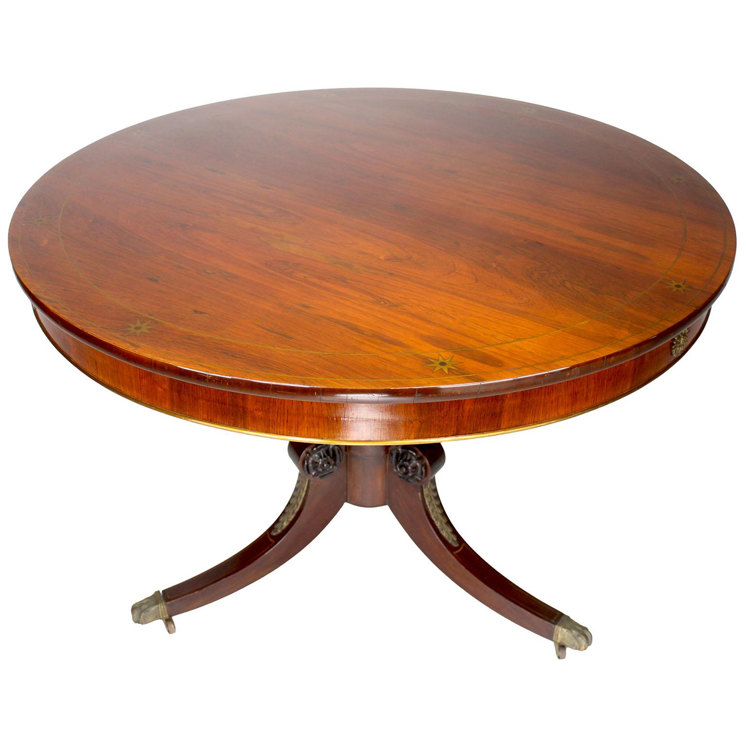A Fine English 19th-20th Century Regency Style Brazilian Rosewood* with Bronze Mounted Circular Game Table, attributed to Maple & Co, London. The round three-legged carved mahogany pedestal game table, the top inlaid with a twin brass trim and stars