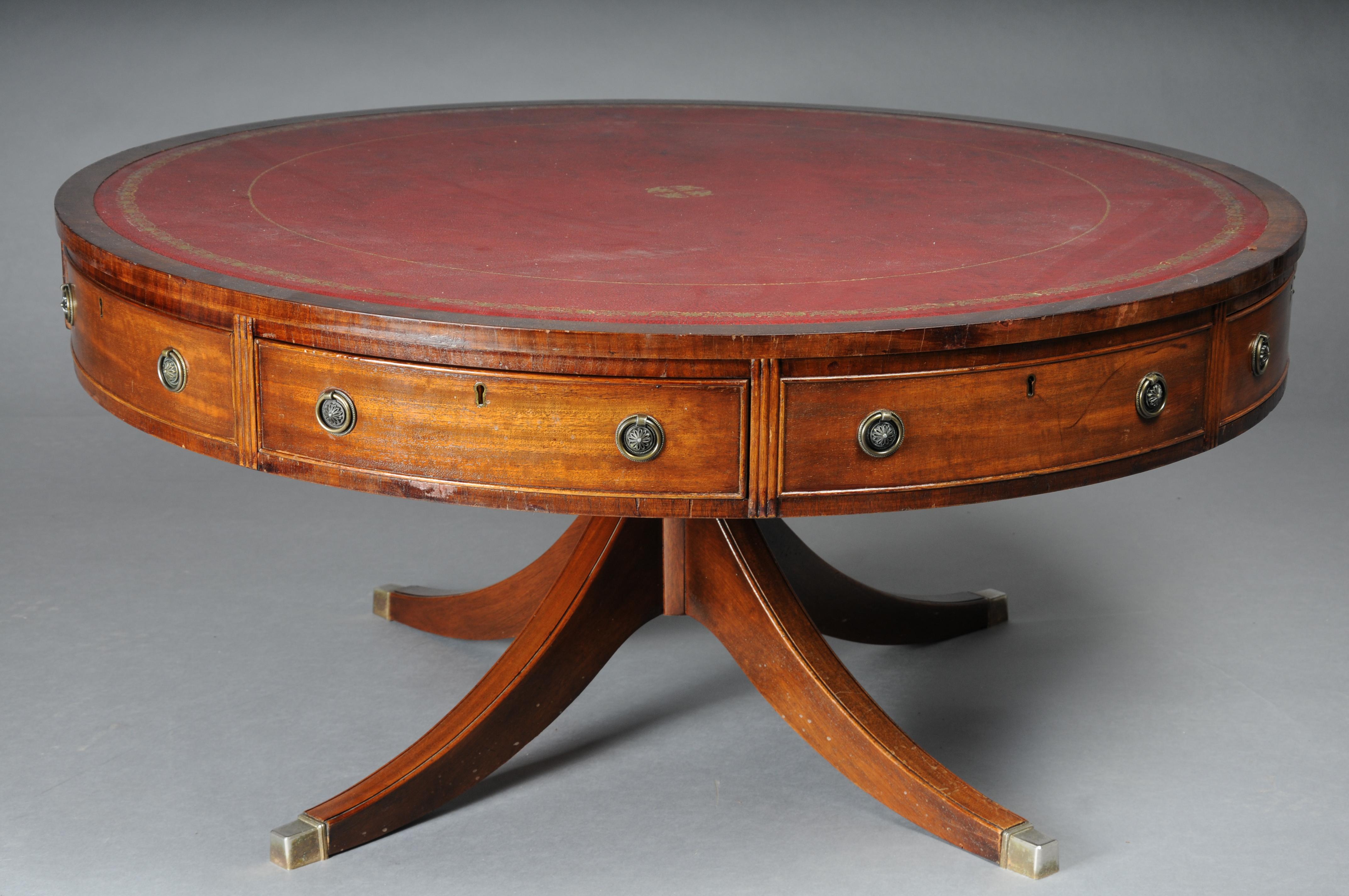 Round English coffee table Chesterfield table, around 1890

Solid wood, round drawer with four drawers. Classic burgundy leather top with gold embossing. Table top stands on four legs that end with brass feet. Victorian England, around 1900