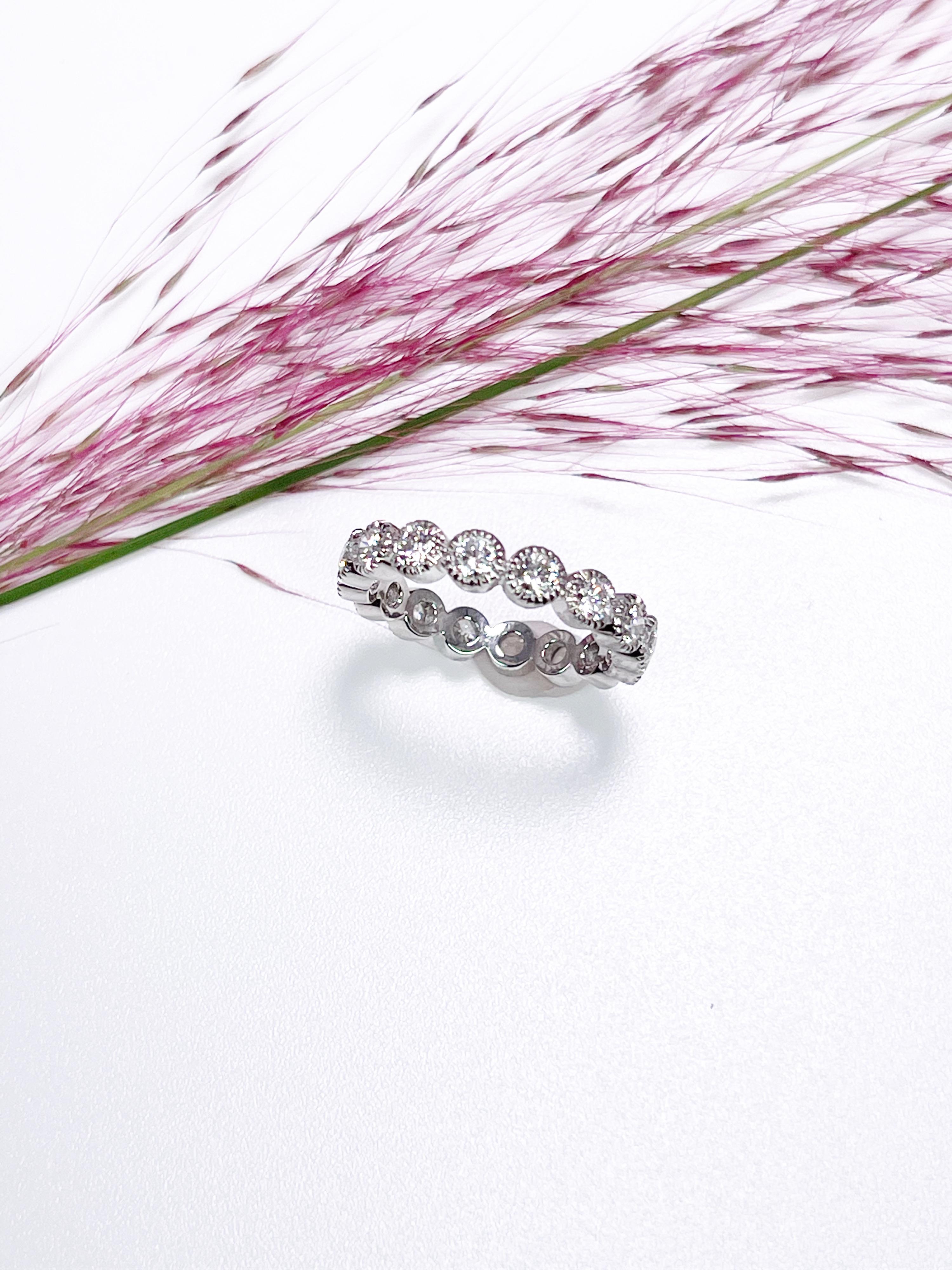 Diamond eternity ring made with round diamonds in platinum. The ring has hand engraving details around every diamond called milgrain.
GRAM WEIGHT: 4.71gr
METAL: platinum

NATURAL DIAMOND(S)
Cut: Round Brilliant
Color: E-F 
Clarity: VS-SI 
Carat: