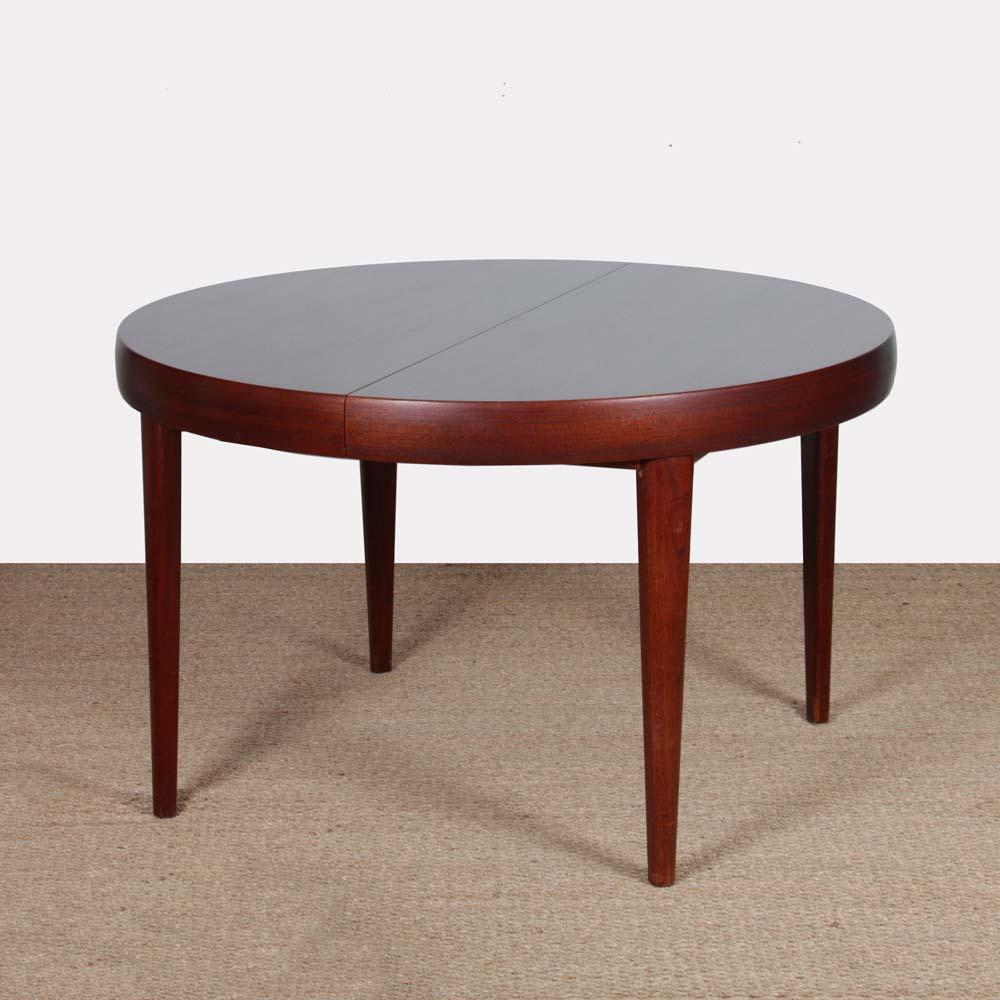 This Rio rosewood round dining table is extendable. It includes a 38 cm extension integrated under the tabletop. It is made in France in the 1960s. This table is in good vintage condition.