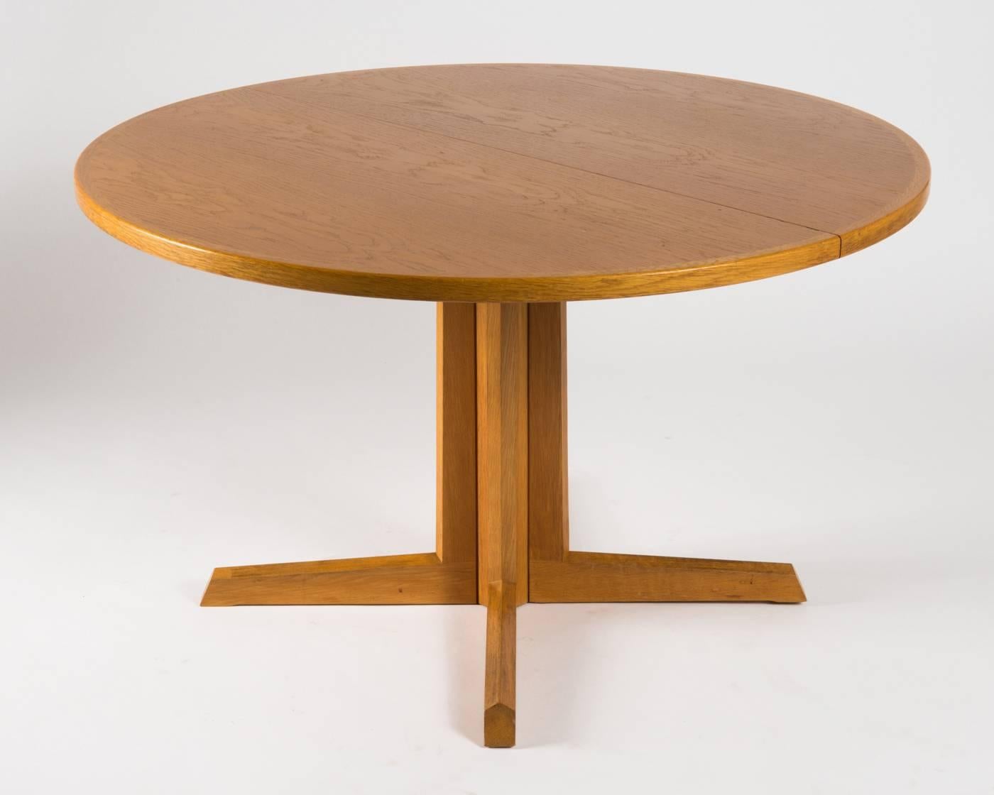 Beautiful round pedestal dining table made in oak designed by N.O. Moller for Gudme Møbelfabrik in the 1960s. Very clean and sharp design with the organic feel that N.O. Moller is known for. The table is extendable with a center leaf and expands
