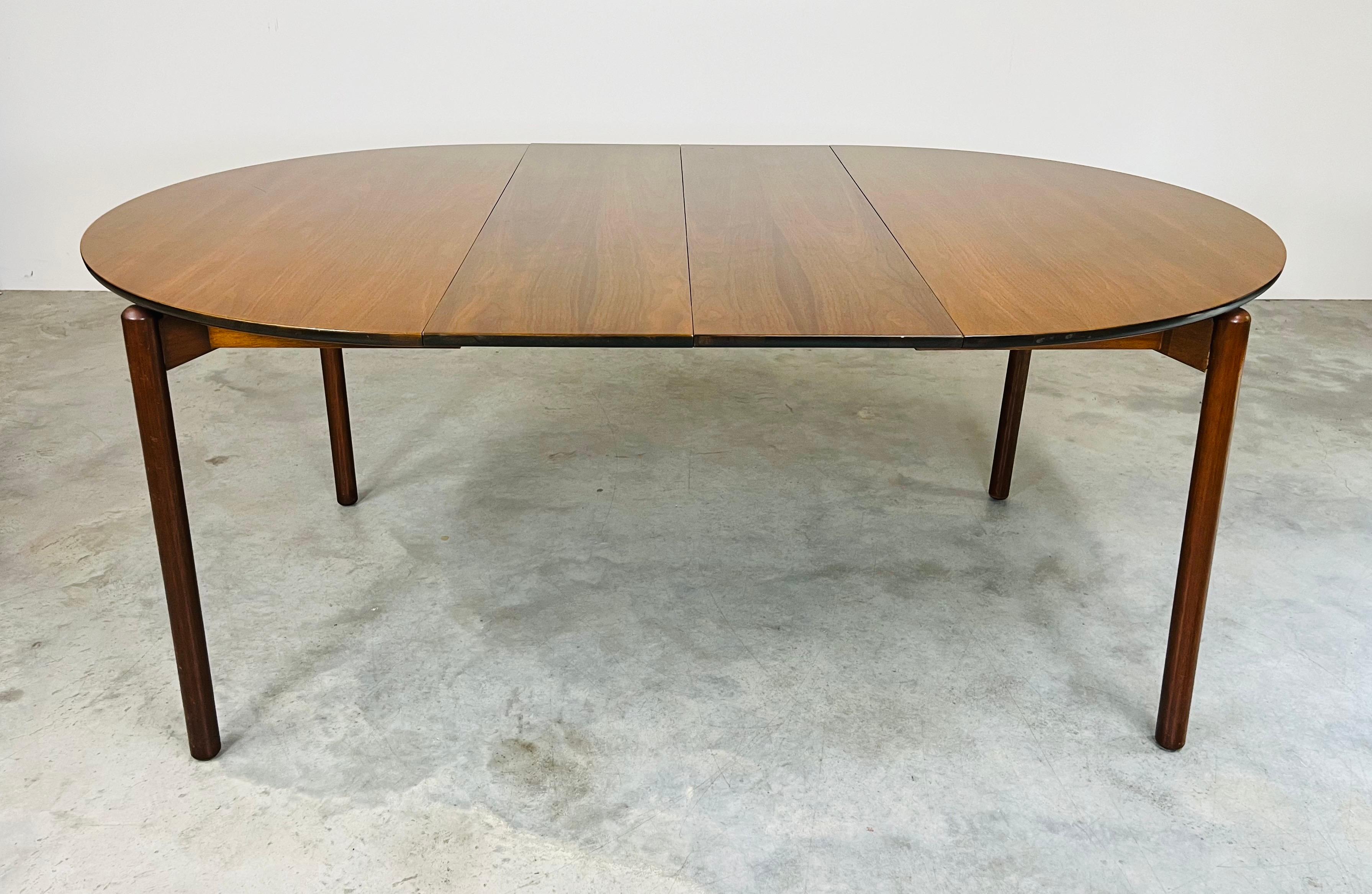 Vintage extendable dining table designed by Greta Magnusson-Grossman for Glenn of California. Solid walnut round top that expands when you unlock via a steel loop with cable to 68 1/2” with the two leaves inserted. The top seamlessly floats over