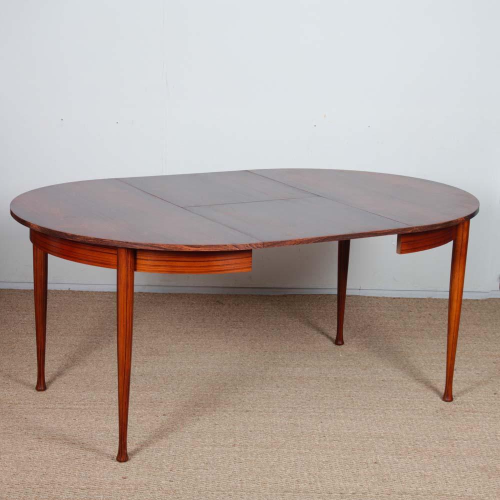 Cette table ronde en bois date des années 1960. Il comprend une rallonge de 50 cm sous le plateau de la table. Cette table est en bon état vintage. La capote a été restaurée.