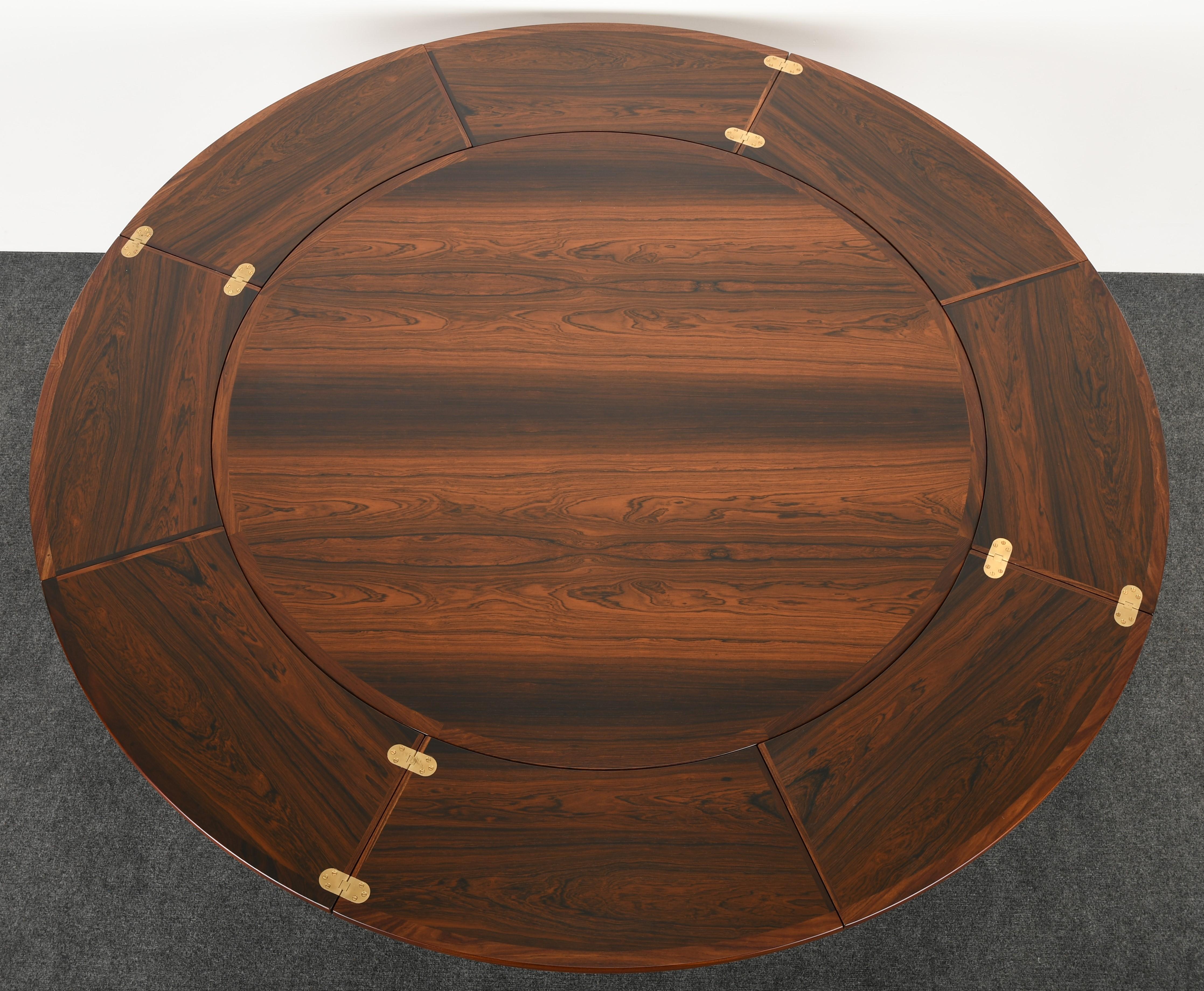 A gorgeous round rosewood flip-top extension table by Dyrlund. This amazing table can be used in several different ways for ample space. The versatile table pulls out from underneath and flips sideways to create a larger table, as shown in the